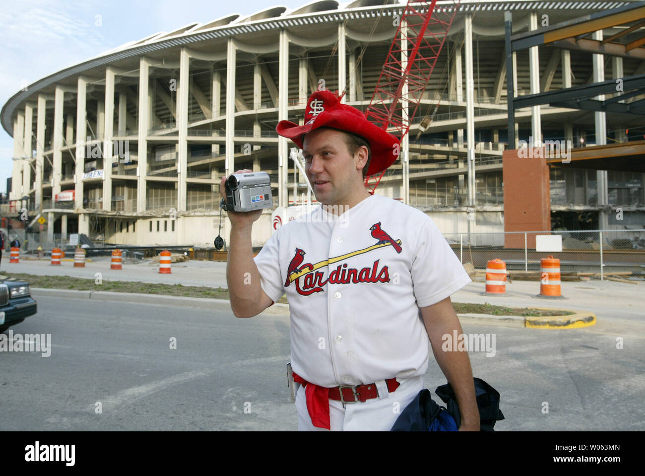 Louis Cardinals ventola Reinnisch Carter film la sua famiglia al di fuori del Busch Stadium come demolizione di 39 anni ballpark inizia a St. Louis il 7 novembre 2005. Gli equipaggi affermano di aver bisogno di sessanta giorni per ottenere la porzione meridionale del ballpark verso il basso in modo che possano completare il nuovo Stadio Busch accanto. Lo stadio è previsto di prendere fino a giugno per essere completamente verso il basso. (UPI foto/Bill Greenblatt) Foto Stock