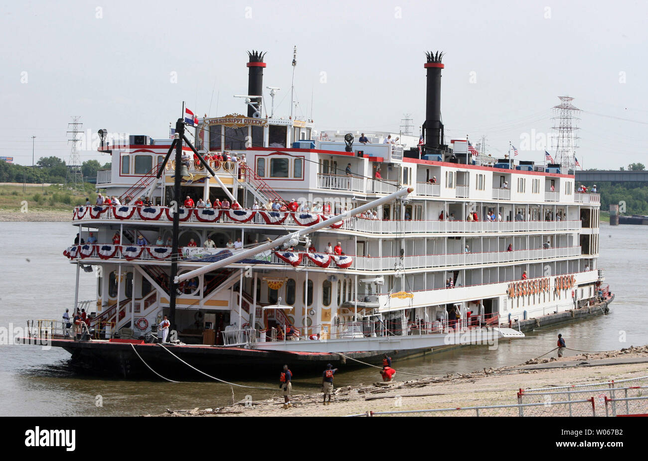 Lavoro Dockhands per fissare il Mississippi Queen Steamboat come dock dopo aver battuto il Delta regina nella grande Gara di Steamboat in San Luigi il 4 luglio 2006. Il 11 giorno di gara ha iniziato a Baton Rouge e finiti al Gateway Arch a St Louis. (UPI foto/Bill Greenblatt) Foto Stock