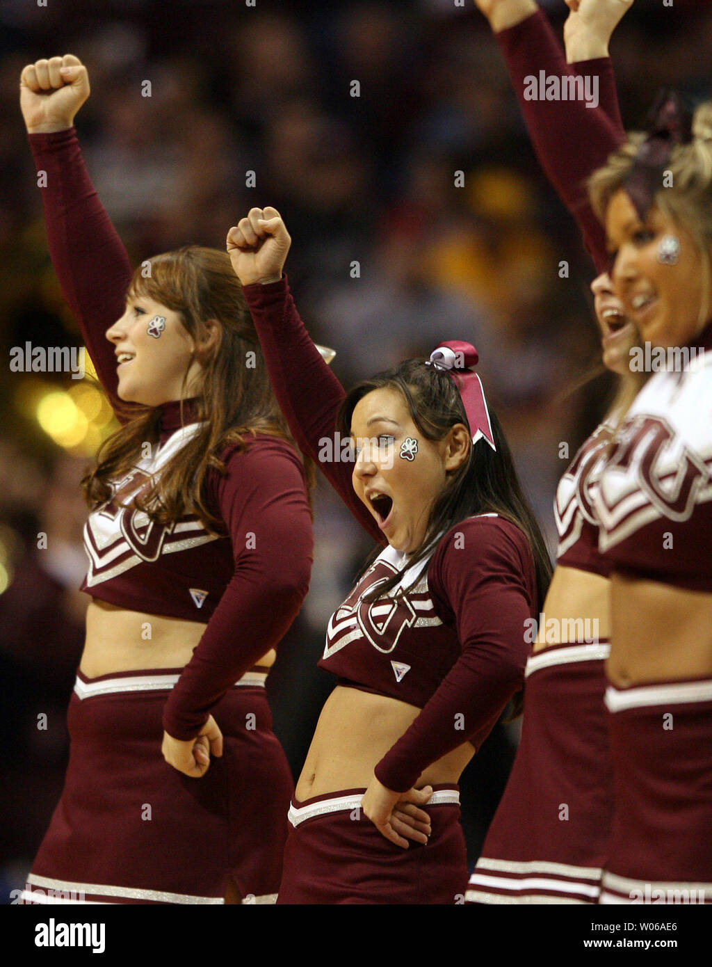 Southern Illinois Salukis cheerleader Kristi Yamaoka (C) cheers come il suo compagno di squadra prende la Creighton Bluejays nella partita di campionato del Missouri Valley Torneo di Scottrade Center di San Luigi il 4 marzo 2007. Yamaoka reso national news un anno fa quando ella cadde al di fuori della parte superiore di una piramide mentre il tifo allo stesso torneo. Come lei era a ruote straped lontano da una barella, Yamaoka eseguito i suoi movimenti con le braccia per la scuola di lotta della canzone. Yamaoka ha subito una frattura al collo in autunno. (UPI foto/Bill Greenblatt) Foto Stock