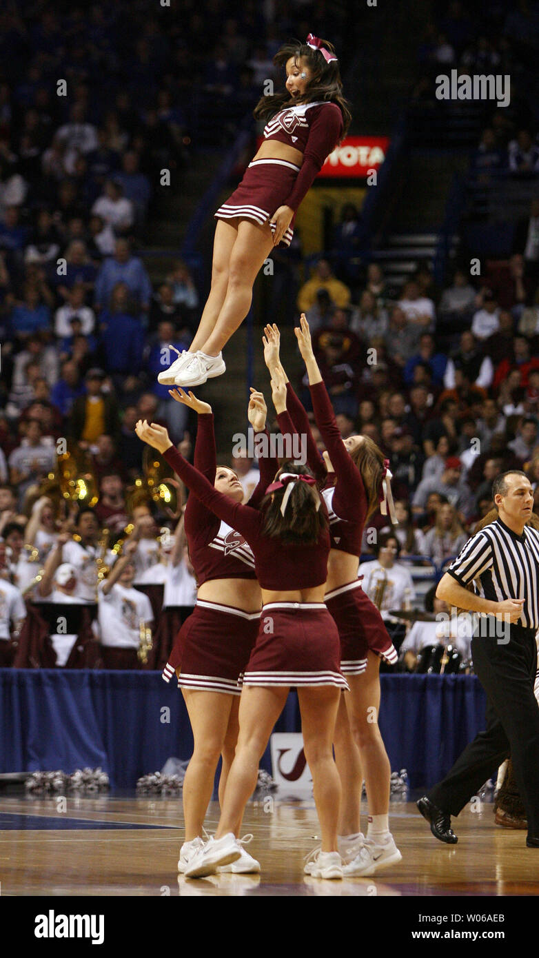 Southern Illinois Salukis cheerleader Kristi Yamaoka decends durante una routine come il suo compagno di squadra prende la Creighton Bluejays nella partita di campionato del Missouri Valley Torneo di Scottrade Center di San Luigi il 4 marzo 2007. Quasi un anno fa per il giorno, Yamaoka fatta di notizie nazionali quando ella cadde al di fuori della parte superiore di una piramide mentre il tifo allo stesso torneo. Come lei era a ruote straped lontano da una barella, Yamaoka eseguite i movimenti con le braccia per la scuola di lotta della canzone. Yamaoka ha subito una frattura al collo in autunno. (UPI foto/Bill Greenblatt) Foto Stock
