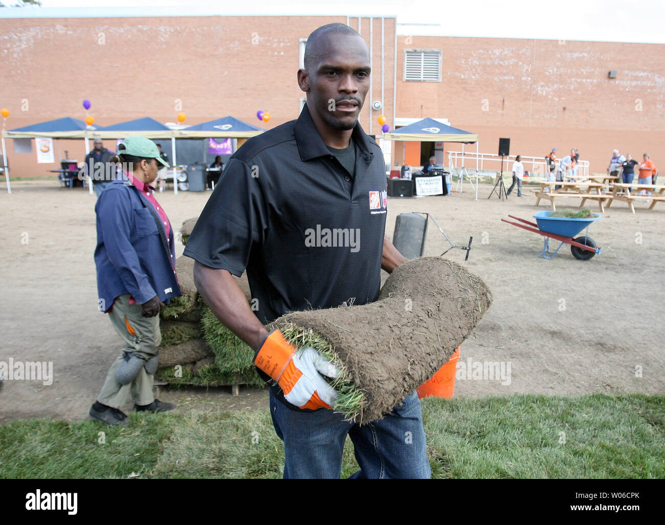 Louis Rams wide receiver Isaac Bruce porta un rotolo di sod come egli aiuta i volontari ri-sod il campo di calcio a nordovest di alta scuola nel nord di San Luigi il 16 ottobre 2007. I lavori di ristrutturazione è parte di uno sforzo nazionale nazionale dal quartiere programma MVP per creare e fissare 1.000 campi in 1.000 giorni. (UPI foto/Bill Greenblatt) Foto Stock