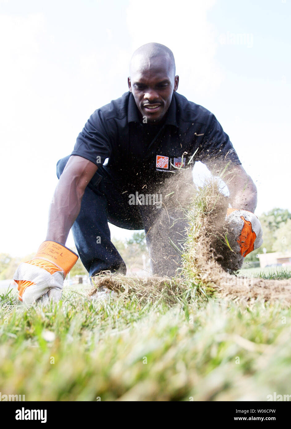 Louis Rams wide receiver Isaac Bruce posiziona il pezzo finale del nuovo ricopra con zolle erbose nel campo di calcio a nordovest di alta scuola nel nord di San Luigi il 16 ottobre 2007. La ristrutturazione del settore è parte di uno sforzo nazionale nazionale dal quartiere programma MVP per creare e fissare 1.000 campi in 1.000 giorni. (UPI foto/Bill Greenblatt) Foto Stock