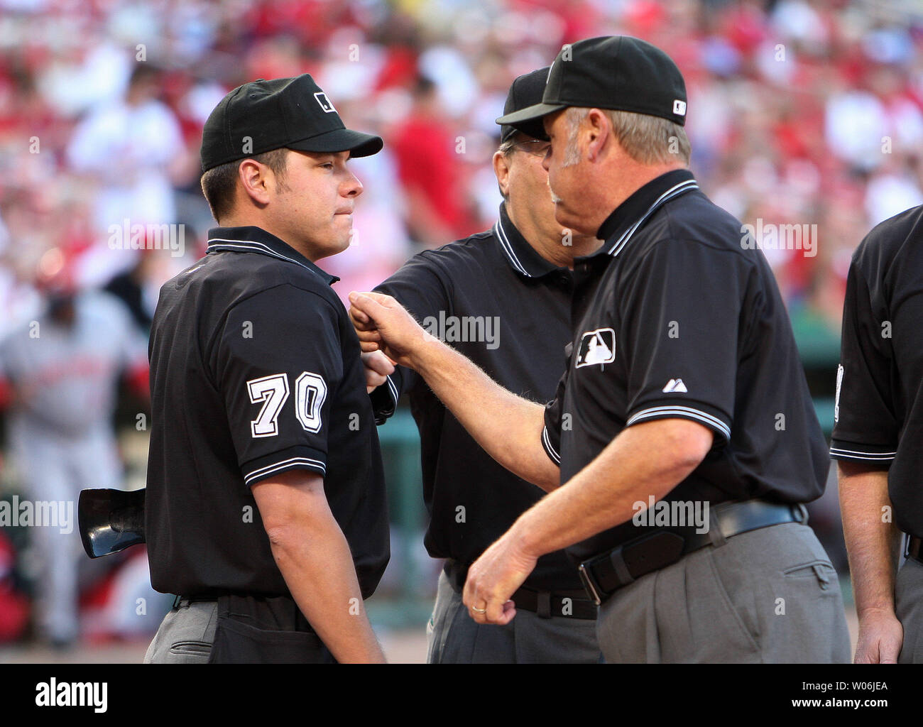 Veterano di arbitri Jim Joyce (R) e cugini Derryl (partally nascosto) pound il torace del rookie umpire homeplate D.J. Reyburn per buona fortuna prima di una partita tra i Cincinnati Reds e St. Louis Cardinals Brian Runge ha un po' di divertimento con il St. Louis Cardinals al Busch Stadium di St Louis il 4 giugno 2009. (UPI foto/Bill Greenblatt) Foto Stock