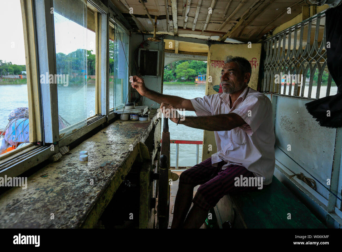 Un marinaio naviga su una nave passeggeri sul fiume Buriganga. Dacca in Bangladesh Foto Stock