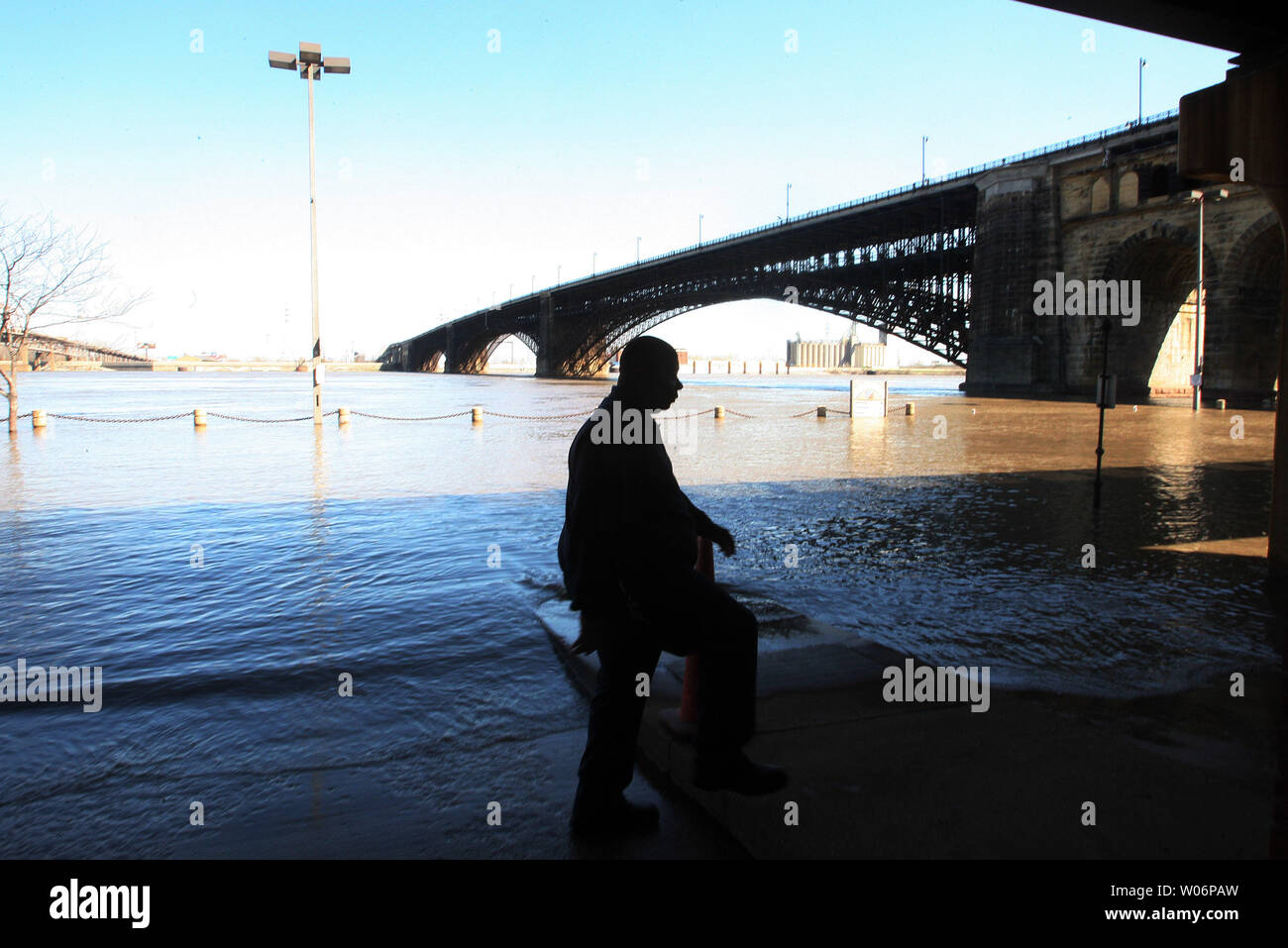 Un visitatore a San Louis riverfront cerca di rimanere fuori la risalita di acque di esondazione del fiume Mississippi sul lungofiume di San Luigi il 30 marzo 2010. Le inondazioni è un fenomeno naturale che avviene per diversi giorni di un anno a causa. UPI/Bill Greenblatt Foto Stock