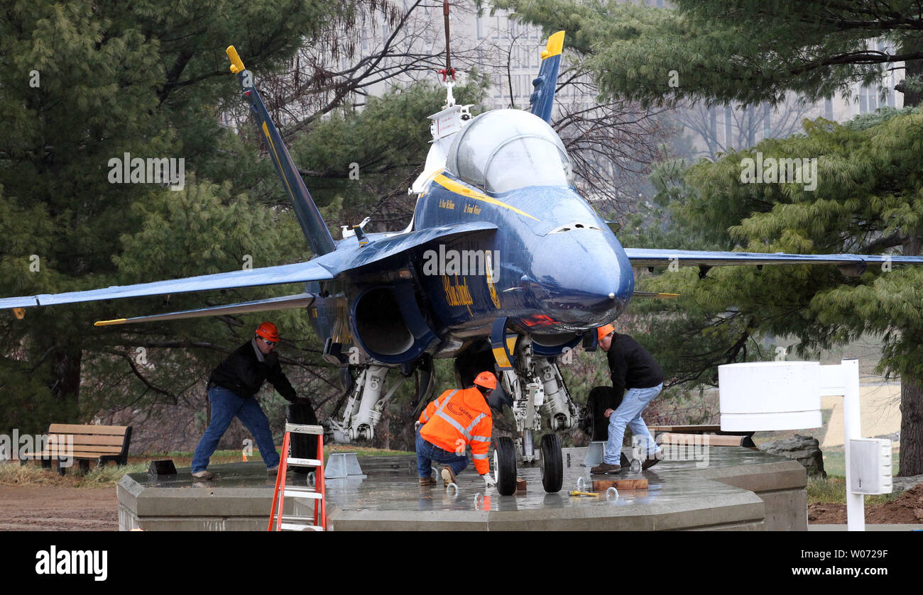 Lavoratori fissare un Blue Angel's jet dopo essere stata abbassata in posizione su un nuovo display a San Louis Science Center di San Luigi il 13 dicembre 2011. Il Blue Angels F/A-18B Hornet è sul prestito permanente dal National Naval Aviation Museum di Pensacola, Florida. UPI/Bill Greenblatt Foto Stock