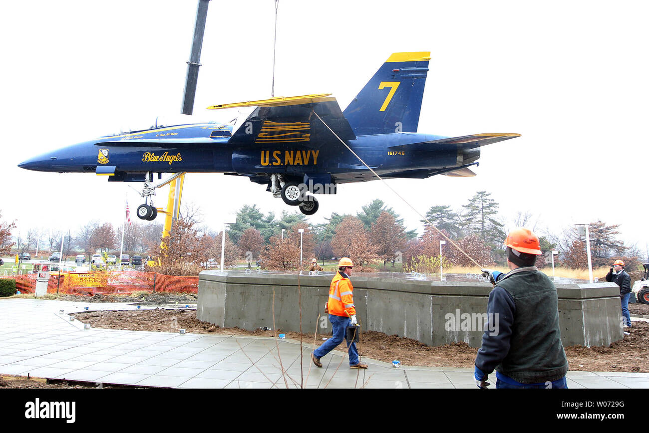 Lavoratori stabile un Blue Angel's jet come è abbassata in posizione su un nuovo display a San Louis Science Center di San Luigi il 13 dicembre 2011. Il Blue Angels F/A-18B Hornet è sul prestito permanente dal National Naval Aviation Museum di Pensacola, Florida. UPI/Bill Greenblatt Foto Stock
