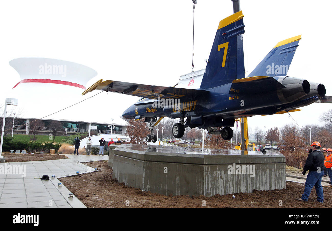 Lavoratori stabile un Blue Angel's jet come è abbassata in posizione su un nuovo display vicino al Planetario al St. Louis Science Center di San Luigi il 13 dicembre 2011. Il Blue Angels F/A-18B Hornet è sul prestito permanente dal National Naval Aviation Museum di Pensacola, Florida. UPI/Bill Greenblatt Foto Stock