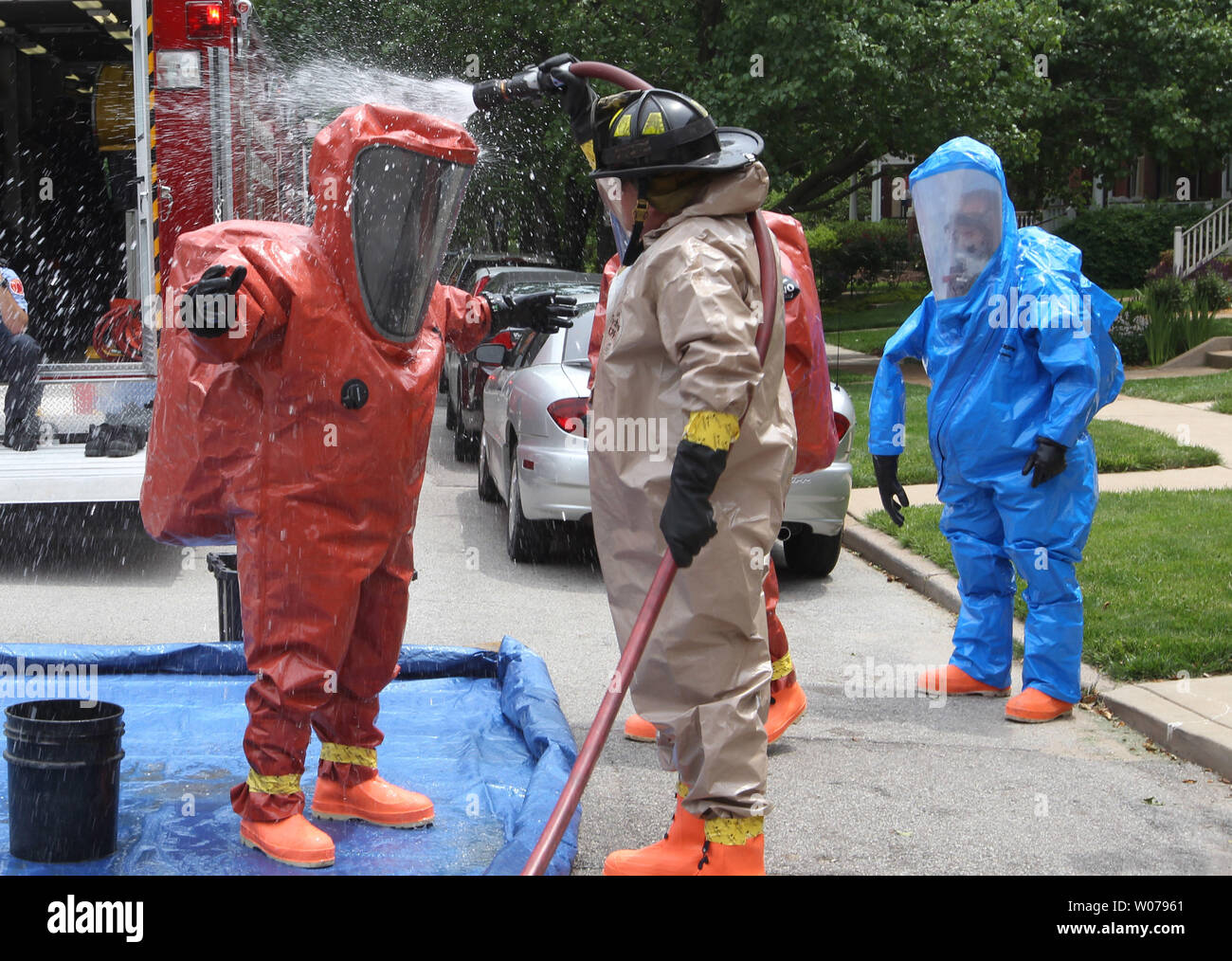 San Luigi vigili del fuoco sono decontaminati in tute di protezione dopo aver esaminato un'ammoniaca anidra perdita in un edificio in fase di ristrutturazione a san Luigi il 5 giugno 2013. Linee di refrigerazione nel seminterrato sono state involontariamente tagliare consentendo una quantità residua di gas di sfuggire. UPI/Bill Greenblatt Foto Stock