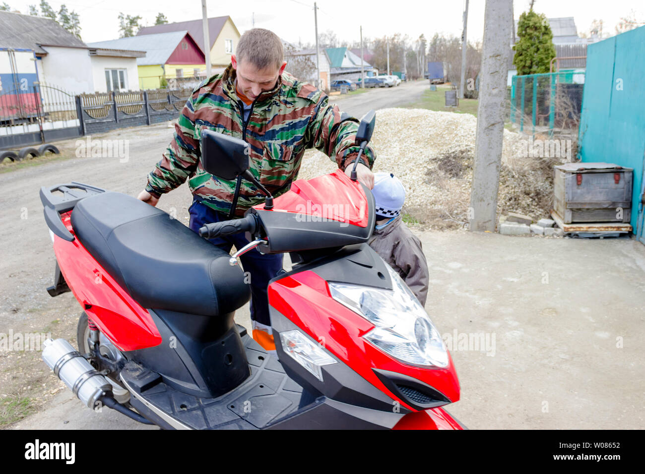 Raffigurata nella foto giovane uomo su una motocicletta rossa all'aperto Foto Stock