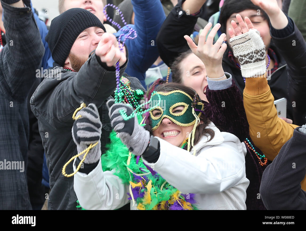 Frequentatori di partito lungo il percorso della parata lotta per talloni gettato da un passante galleggianti durante il quarantesimo Mardi Gras Parade di San Luigi il 3 marzo 2019. Foto di Bill Greenblatt/UPI Foto Stock