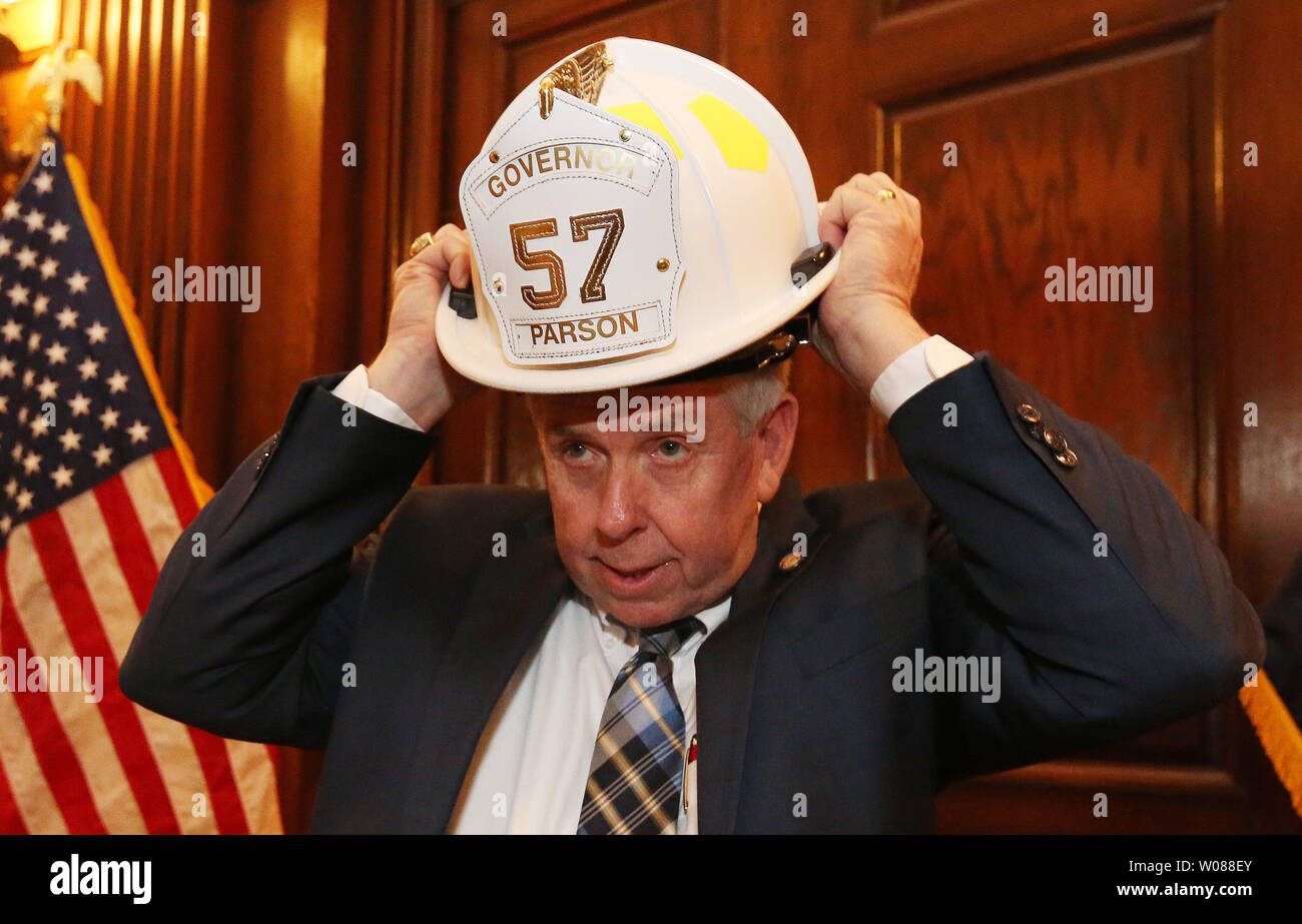 Missouri Governatore Mike Parson cerca sul suo casco vigile del fuoco a lui presentati durante le cerimonie in Missouri State vigili del fuoco giornata presso il Campidoglio nella Città di Jefferson, Missouri il 6 marzo 2019. Vigili del fuoco da tutto lo stato visitato il loro stato represenatives per discutere di una normativa che consentirà di salvare la vita vigile del fuoco che coinvolgono il cancro, il più grande killer di America's vigili del fuoco. Foto di Bill Greenblatt/UPI Foto Stock