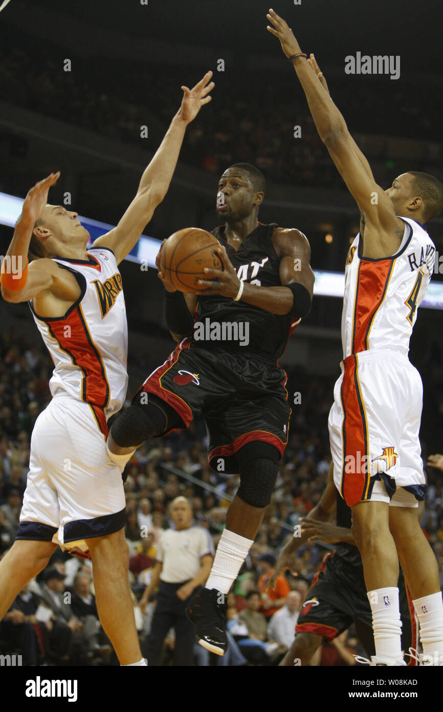 Miami Heat's Dwyane Wade (3) tenta di mettere su un colpo tra Golden State Warriors Andris Biedrins (L) e Anthony Randolph nel primo semestre presso la Oracle Arena di Oakland, la California il 1 dicembre 2008. (UPI foto/Terry Schmitt) Foto Stock