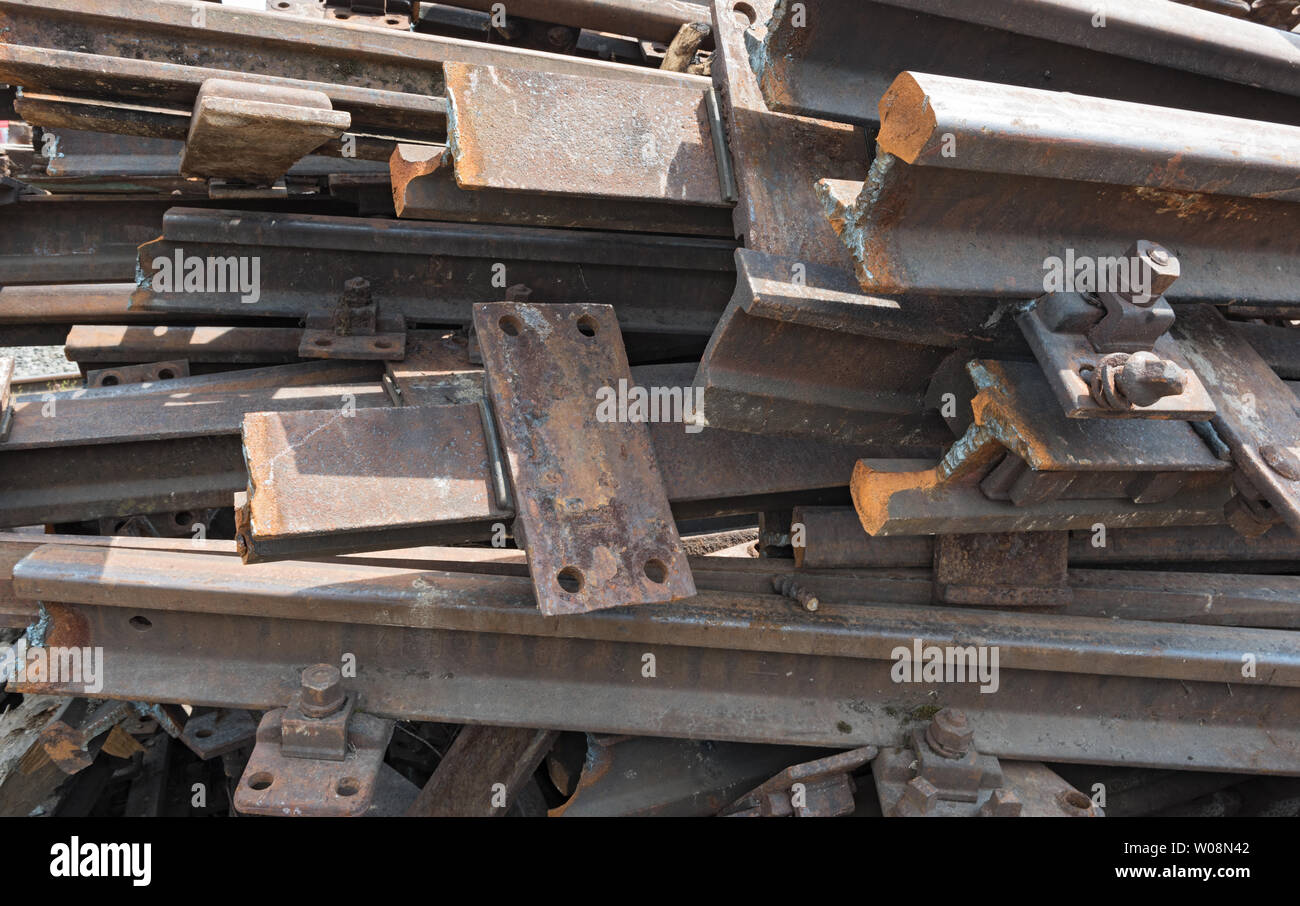 Vecchio arrugginito i binari della ferrovia per la demolizione in uno spazio di magazzino Foto Stock