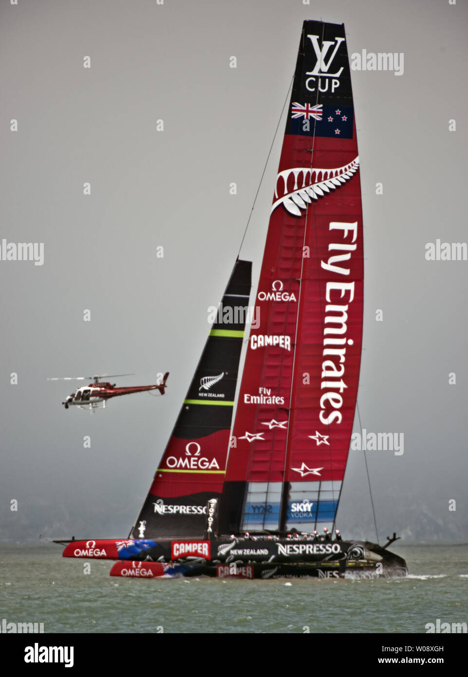 Emirates Team New Zealand vele passato un elicottero nella Louis Vuitton Cup la Coppa America serie Challenger, in una gara di incontrastata sulla Baia di San Francisco il 9 luglio 2013. La Nuova Zelanda è stato pianificato per la gara Artemis Racing, ma il team svedese è ancora assemblare la sua seconda AC72 vela e catamarano non sarà pronta a salpare per altre due settimane. UPI/Terry Schmitt Foto Stock