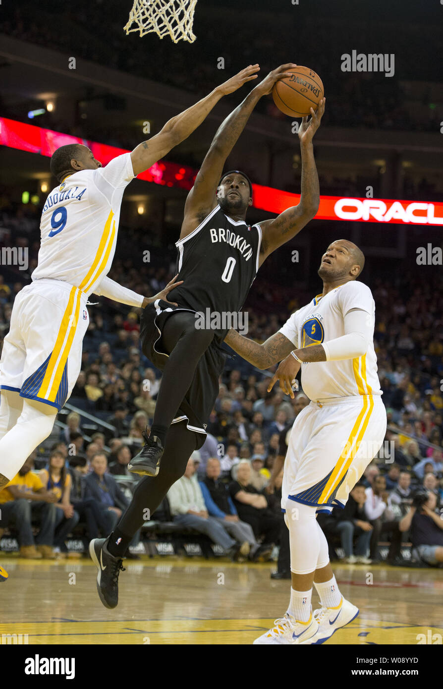 Reti di Brooklyn Andray Blatche (0) va contro il Golden State Warriors Andre Iguodala (9) e Marreese Speights (5) nel primo semestre presso Oracle Arena di Oakland, la California il 22 febbraio 2014. UPI/Terry Schmitt Foto Stock