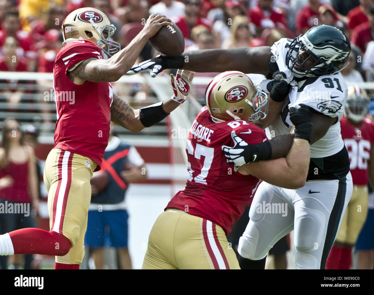 Philadelphia Eagles Fletcher Cox (91) tenta di raggiungere San Francisco 49ers QB Colin Kaepernick sopra il blocco di centro Daniel Kilgore (67) nel primo trimestre a Levi's Stadium di Santa Clara, California, 28 settembre 2014. UPI/Terry Schmitt Foto Stock