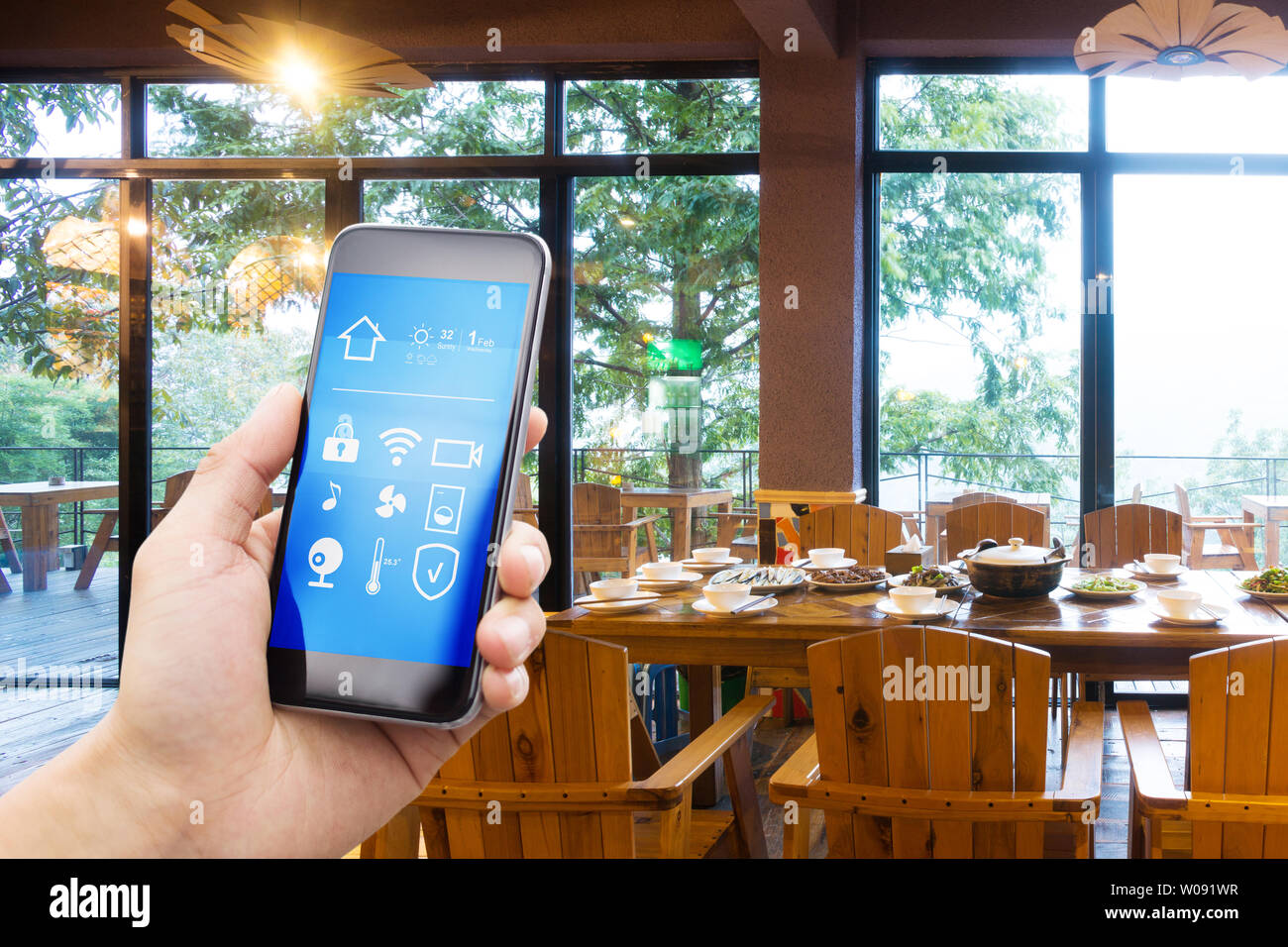 Smart phone con casa intelligente e moderno ristorante in hotel Foto Stock