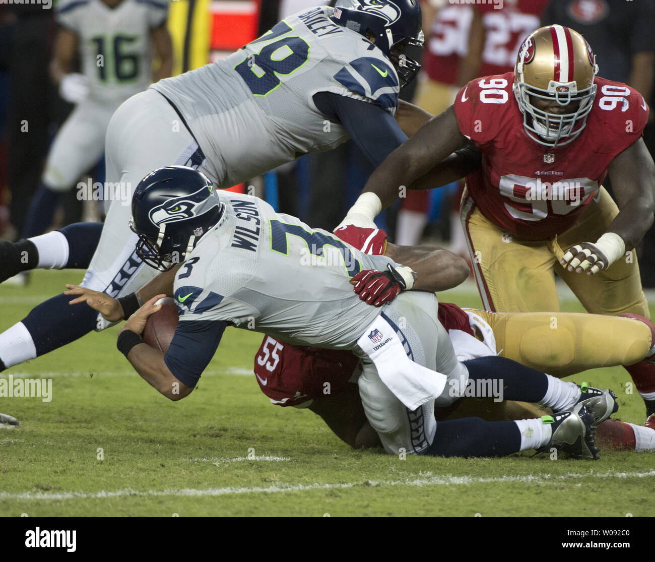 Seattle Seahawks QB Russell Wilson (3) ho saccheggiato per una perdita del cantiere da parte di San Francisco 49ers Ahmad Brooks (55) nel secondo trimestre a Levi's Stadium di Santa Clara, in California, il 22 ottobre 2015. Il Seahawks sconfitto il 49ers 20-13. Foto di Terry Schmitt/UPI Foto Stock