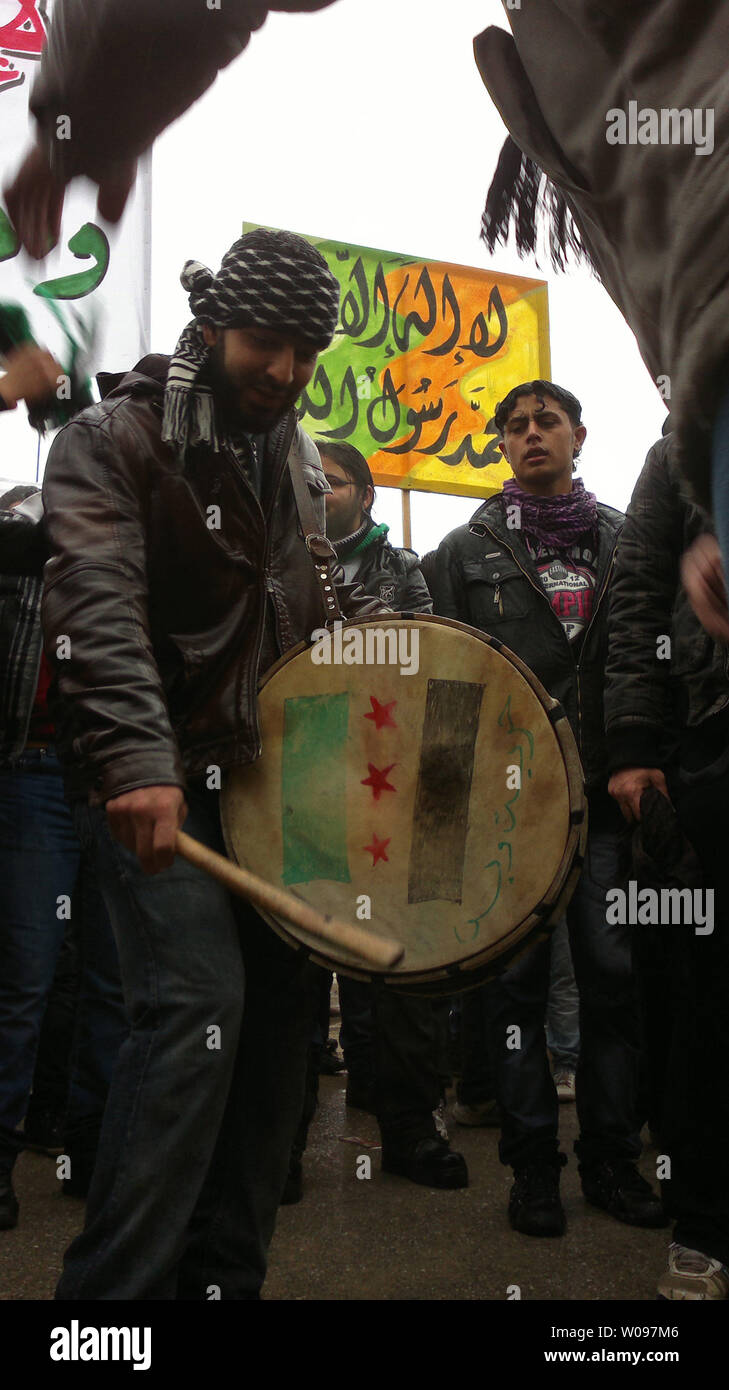 I manifestanti gridare slogan come essi onda indipendenza siriana bandiere durante una manifestazione di protesta contro la Siria il presidente Bashar Al-Assad, dopo la preghiera del venerdì in Idlib, Siria, il 17 febbraio 2012. UPI Foto Stock