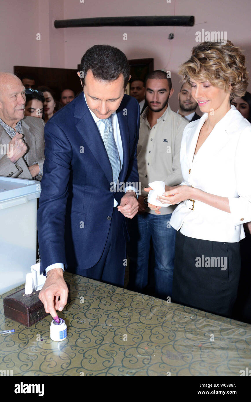 In questa foto rilasciata dalla Siria il national news agency, il Presidente siriano Bashar al-Assad e Siriana e la first lady Assam Assad votare nel paese di elezione presidenziale in corrispondenza di una stazione di polling in Maliki, una zona residenziale nel centro della capitale Damasco, Siria, il 3 giugno 2014, siriani schierate al di fuori dei centri di polling nel governo-aree controllate in tutto il paese a votare martedì per le elezioni presidenziali che Assad è ampiamente previsto per vincere ma che l'opposizione in esilio ha sbattuto come un 'farsa'. UPI Foto Stock