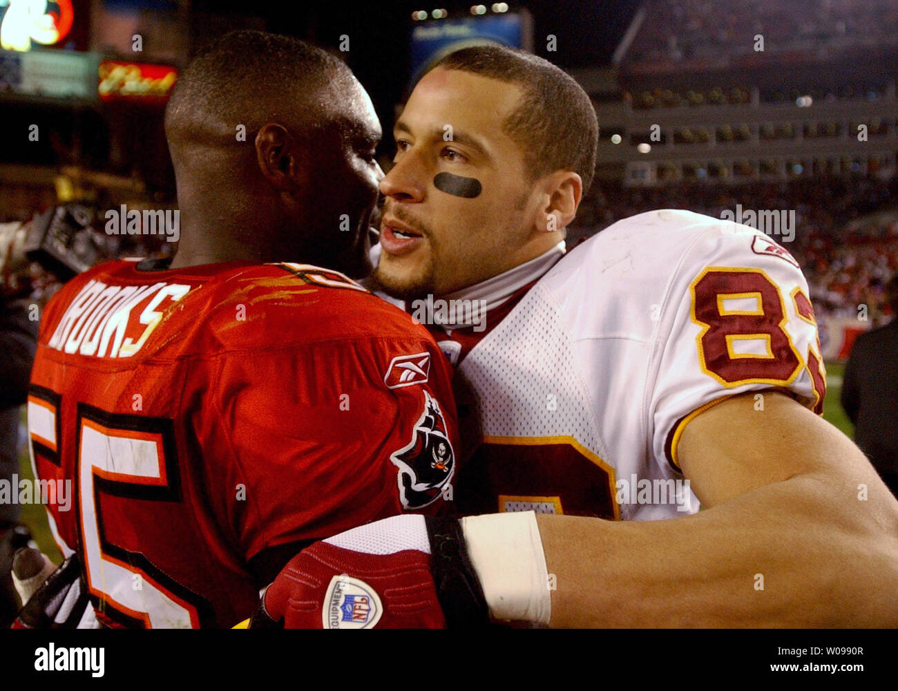Tampa Bay Buccaneers' linebacker Derrick Brooks (sinistra) abbracci Washington Redskins' wide receiver James Thrash (destra) dopo le pellerosse battere i bucanieri 17-10 presso Raymond James Stadium Gennaio 7, 2006 a Tampa, FL. (UPI foto/Cathy Kapulka) Foto Stock