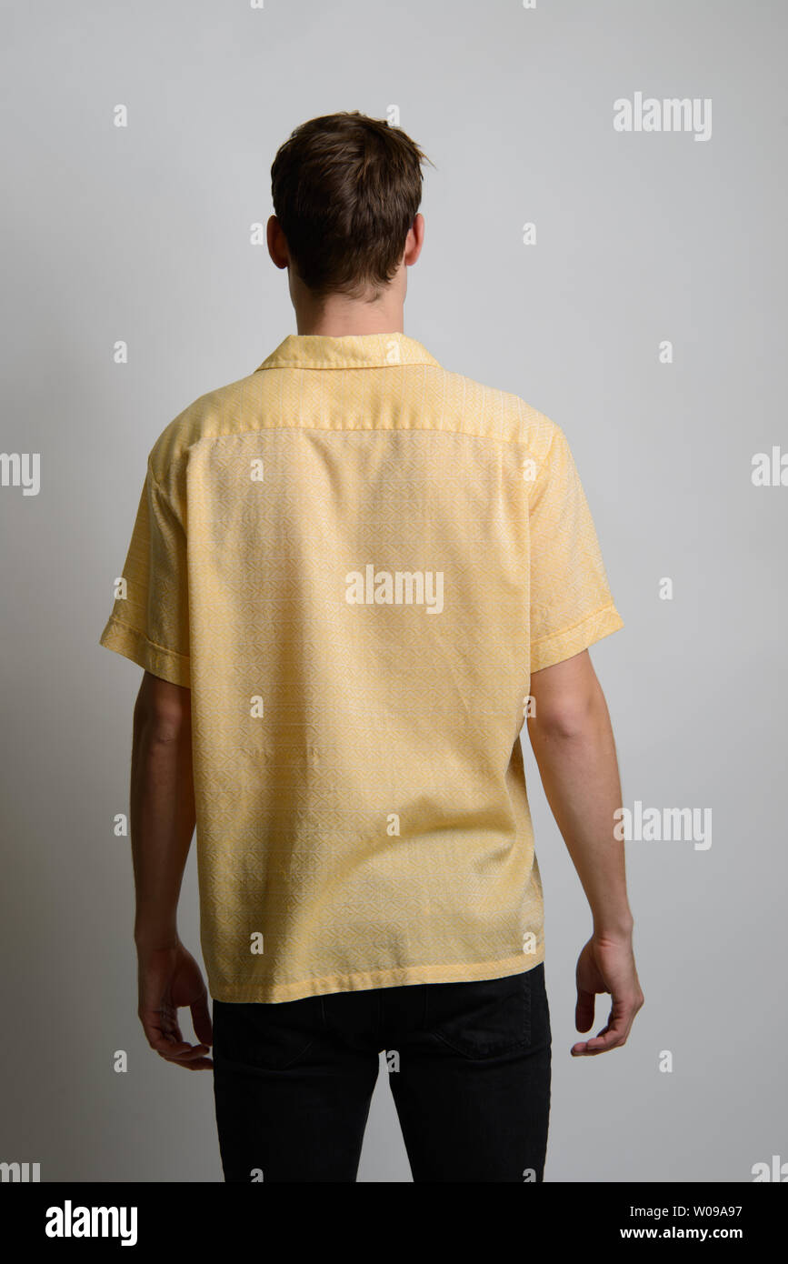 Un modello maschio caucasico di capelli marroni pone in vestito vintage, fotocamera di fronte alla schiena, un editoriale di moda vintage maschile. Foto Stock