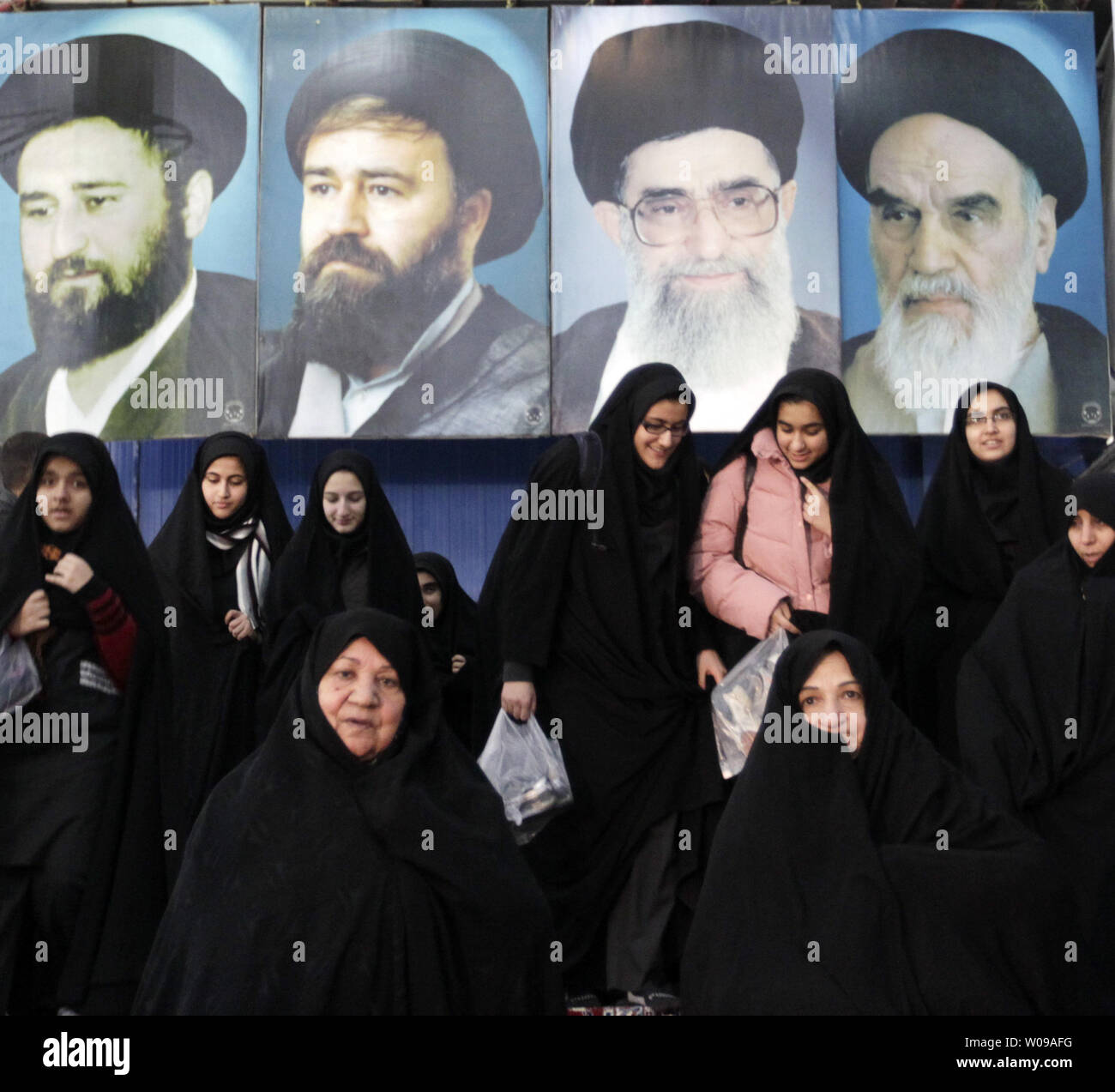 Le donne iraniane passare dalle immagini dell Ayatollah Ruhollah Khomeini, il fondatore della repubblica islamica (1st-R) e all'Iran il leader supremo Ayatollah Ali Khamenei (2nd-R) durante una celebrazione in occasione del primo anniversario del ritorno 1979 dell Ayatollah Khomeini dall esilio presso il mausoleo del tardo rivoluzionario fondatore Ayatollah Khomeini il 1 febbraio 2012. UPI/Maryam Rahmanian.. Foto Stock