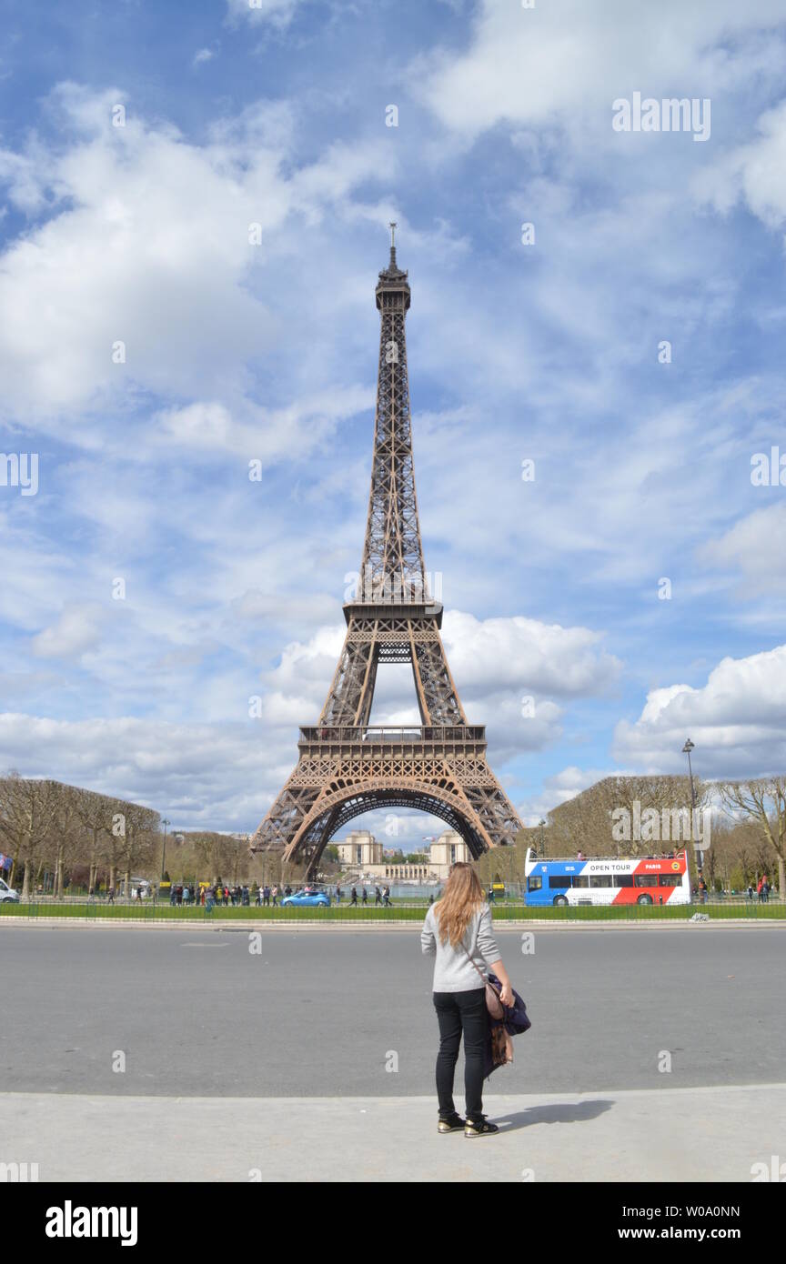 Una donna sta guardando a Tour Eiffel a Parigi, Francia Foto Stock