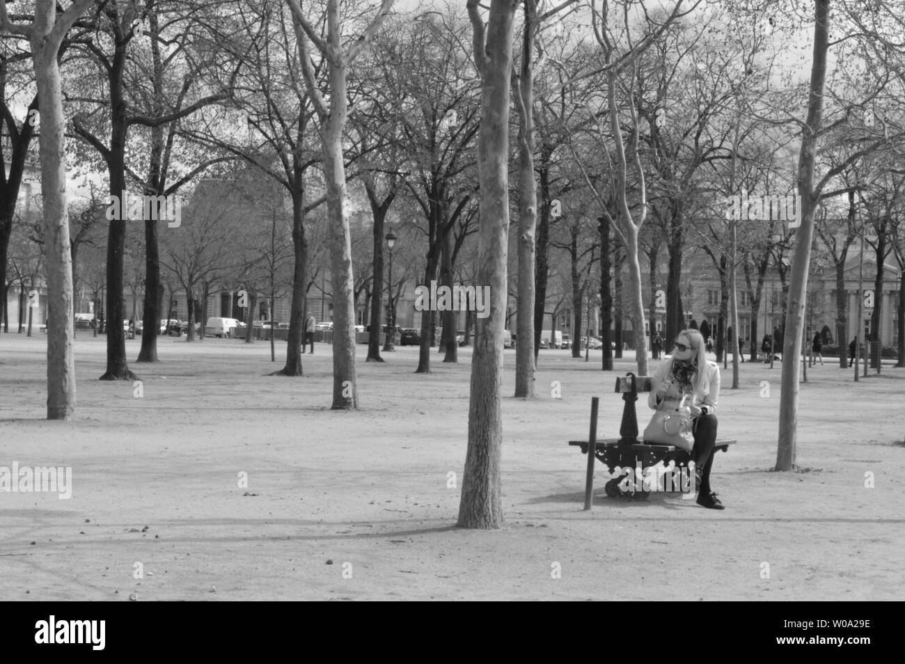 Una donna è seduto da solo in un parco aperto a Parigi, Francia Foto Stock