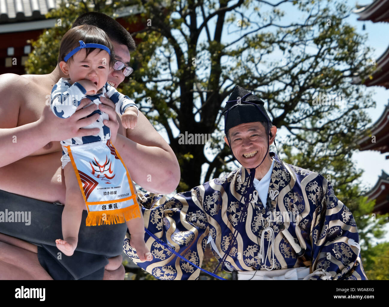 Un bambino tenuto da un dilettante lottatore di sumo grida durante il 'baby pianto contest (Naki Sumo)" presso il tempio di Sensoji a Tokyo in Giappone il 28 aprile 2019. Questo concorso avviene per i genitori che desiderano una buona salute e di forza per i bambini dal 1986. Foto di Keizo Mori/UPI Foto Stock