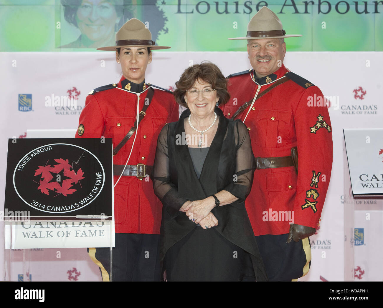 Affiancato dal RCMP ufficiali, ex Alto Commissario delle Nazioni Unite per i Diritti Umani e il Procuratore capo per due Tribunali penali internazionali Louise Arbour svela la sua stella sul tappeto giallo dove lei sarà introdotto nel 2014 Canada's Walk of Fame nel corso di cerimonie presso il Sony Center for the Performing Arts a Toronto, Ontario Ottobre 18, 2014. UPI/Heinz Ruckemann Foto Stock