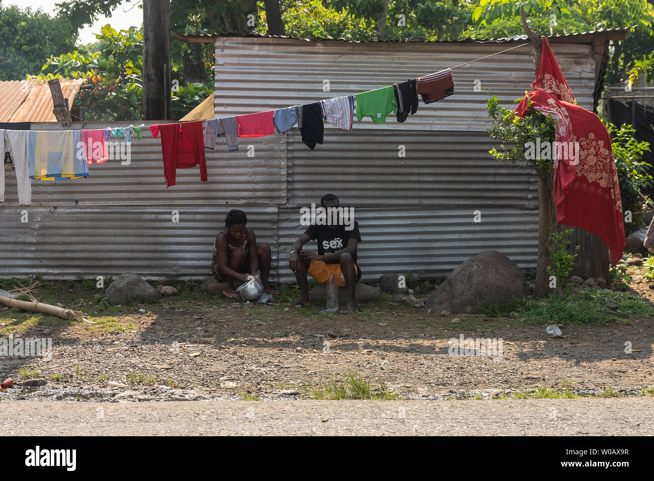 Un uomo e una donna sedersi al di sotto di una linea di abbigliamento in Tapachula, Messico il 9 maggio 2019. I migranti provenienti da Africa e Haiti hanno temporaneamente si insediarono vicino al (INM) Instituto Nacional de Migración Delegación Federal en Chiapas edificio mentre sperando per richiedere un visto di uscita in modo che possano rendere il loro modo per gli Stati Uniti-Messico frontiera. Foto di Ariana Drehsler/UPI Foto Stock