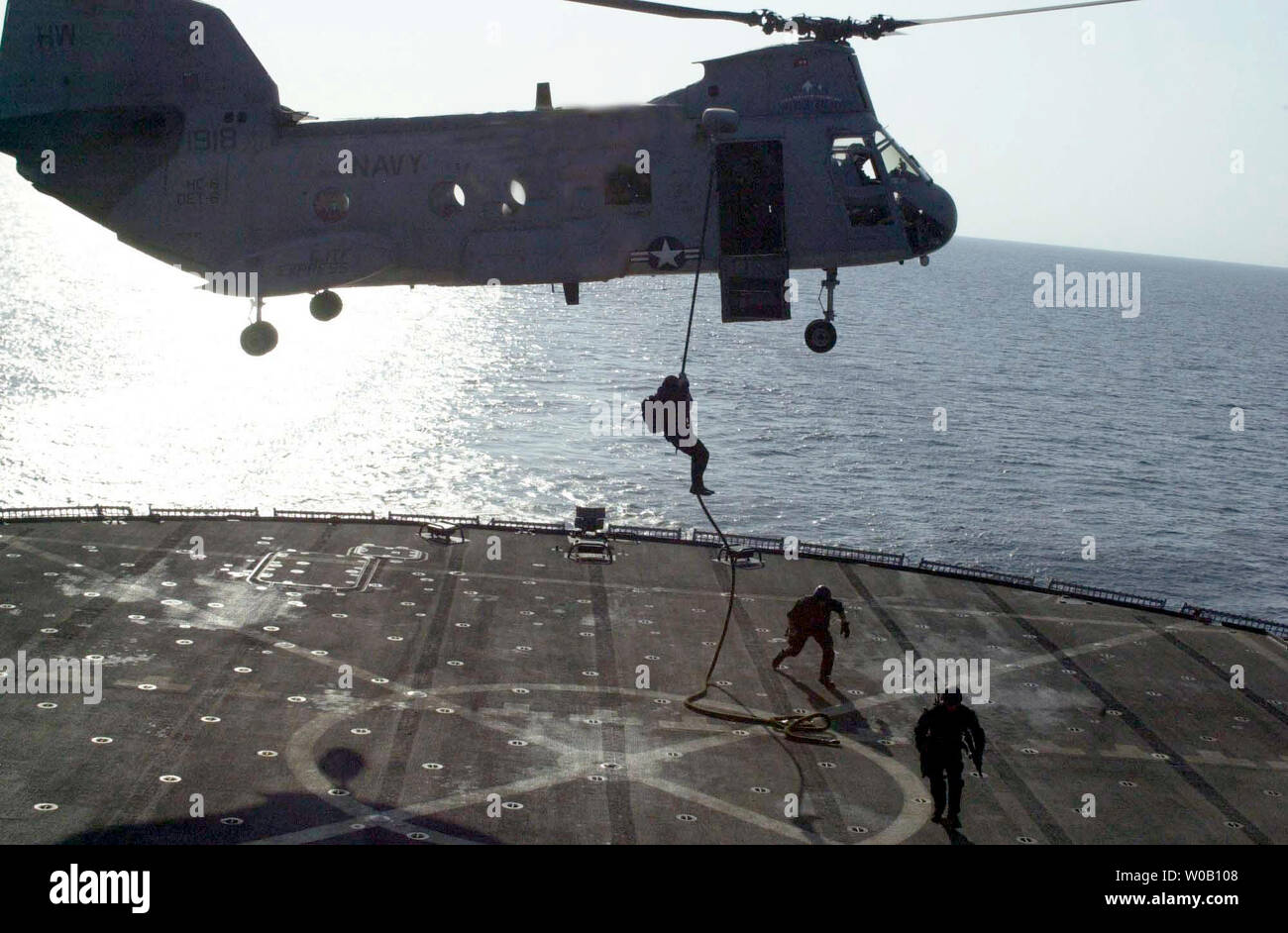 Cera2003011702- in mare a bordo della USS Mount Whitney, gen. 17 (UPI) - STATI UNITI Navy SEAL (mare, aria e terra) fast-corde da un MH-53 ÒPave LowÓ elicottero durante una intercettazione marittima funzionamento allenamento esercizio. Stati Uniti Navy SEALs sono distribuiti in tutto il mondo condurre missioni a sostegno dell'Operazione Enduring Freedom. cc/USN/George R. Kusner UPI Foto Stock