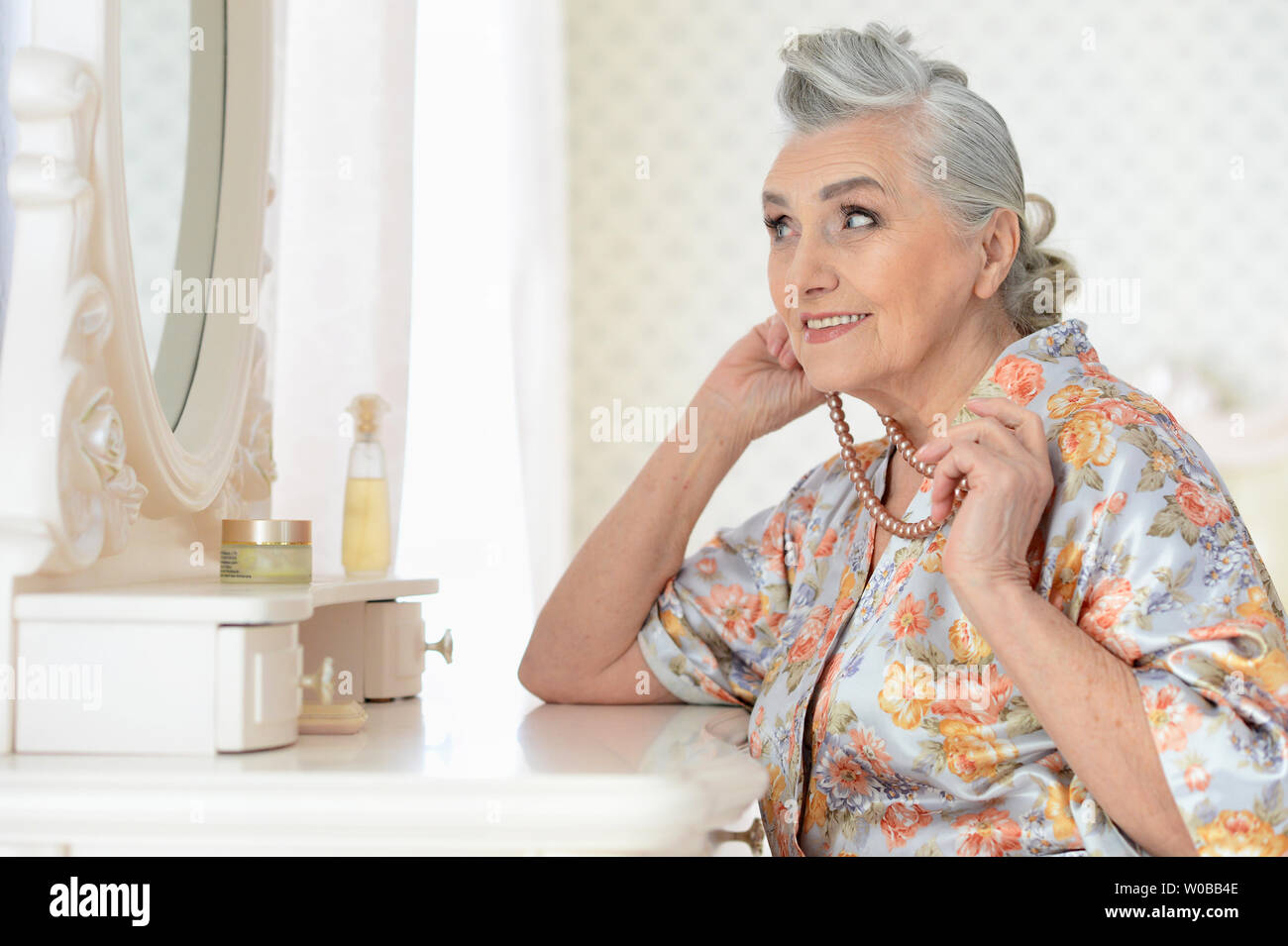 Ritratto di felice donna senior di applicare il trucco Foto Stock