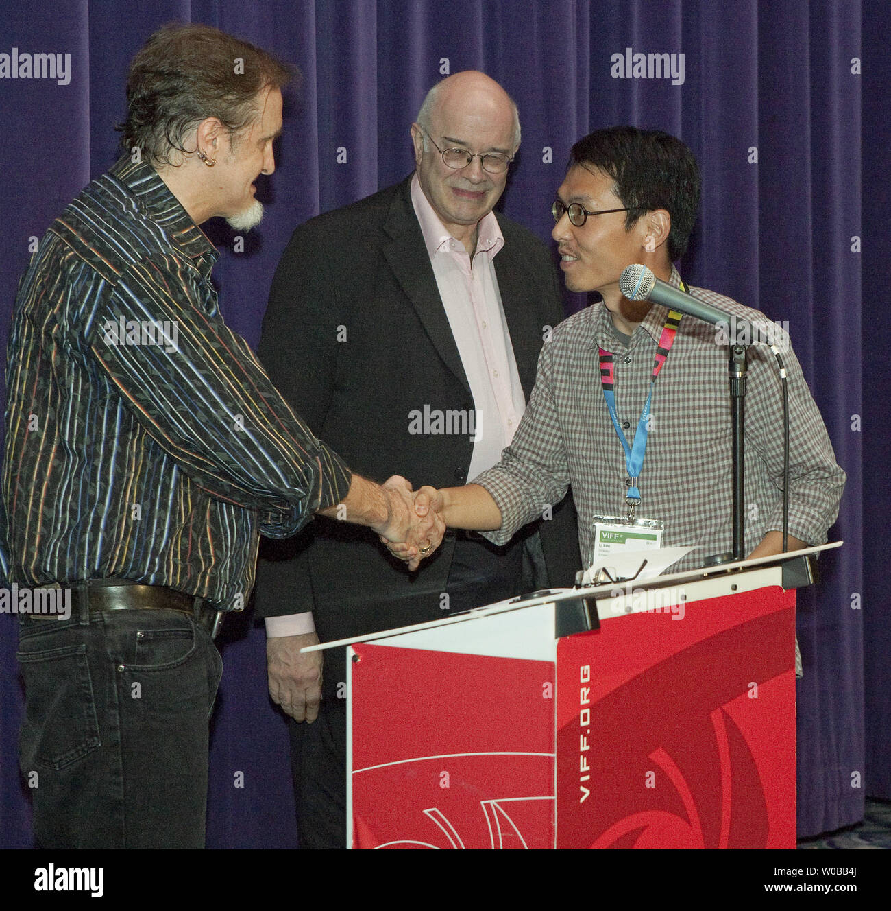 Programmatore Tony Raynes si preannuncia come uno dei tre giudici, film giornalista e docente Chuck Stephens (L) si congratula con la Cina del Li Luo il vincitore del 2012 Vancouver International Film Festival draghi e Tigers Award per il cinema giovane insieme con il suo premio in denaro di USD 5,000.00 per il film "L'imperatore visiti l'Inferno" durante il Vancouver International Film Festival di Vancouver, British Columbia il 4 ottobre 2012. UPI Foto /Heinz Ruckemann Foto Stock