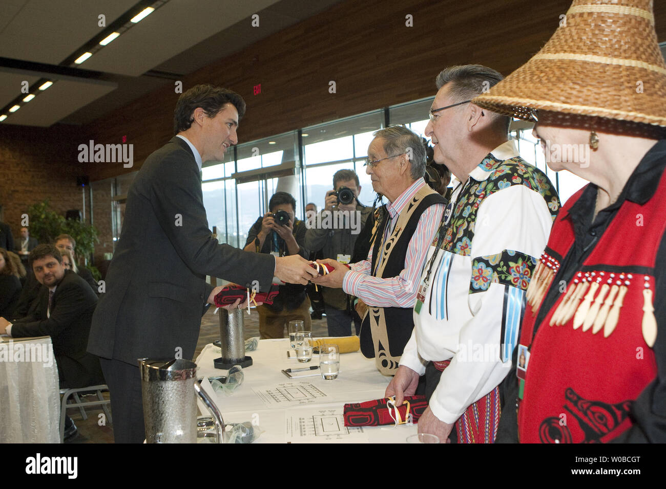 Il primo ministro canadese Justin Trudeau presenta un regalo a Musqueam elder Larry concedere nel corso di un incontro con i leader indigeni prima di un primo incontro dei ministri in Vancouver, BC, Marzo 2, 2016. Canada's provinciali e territoriali i leader sono in città per il 2016 incontro invernale del Canada è Premiers. UPI/Heinz Ruckemann Foto Stock