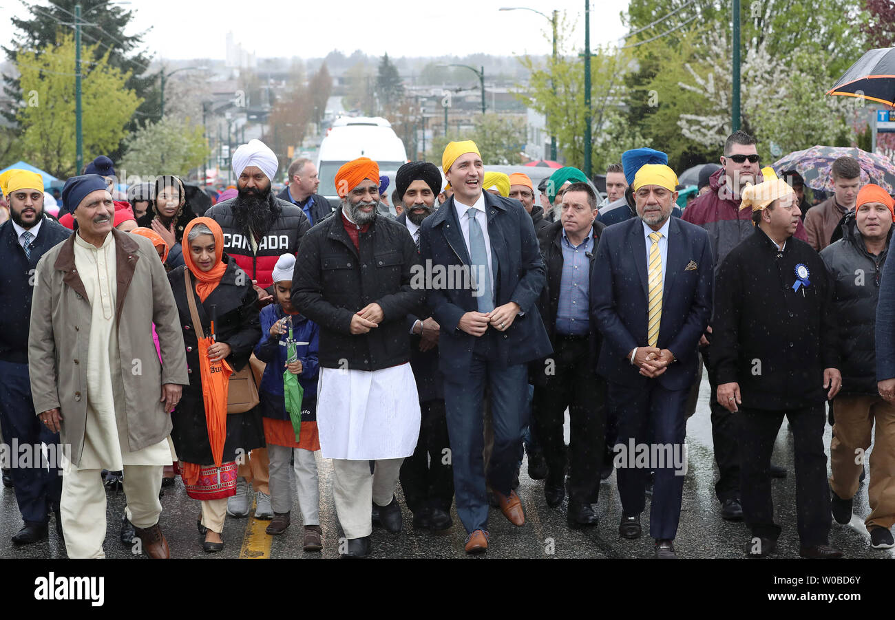 Il ministro liberale di Difesa Nazionale Harjit Sajjan e il Primo Ministro Justin Trudeau (Centro L. & R.) condividono una risata come cammina per la parata Vaisakhi in umido, ventoso dopo aver parlato a Khalsa Diwan della società Ross Street Temple durante Vaisakhi celebrazioni in Vancouver, British Columbia, il 13 aprile 2019, dopo che il loro governo ha di recente eliminato un riferimento di estremismo Sikh da un terrorismo 2018 relazione. Decine di migliaia di persone partecipano a questo annuale Punjabi harvest festival che commemora la fondazione della Khalsa nel 1699 dal Guru Gobind Singh e è uno dei più grandi nel Nord un Foto Stock