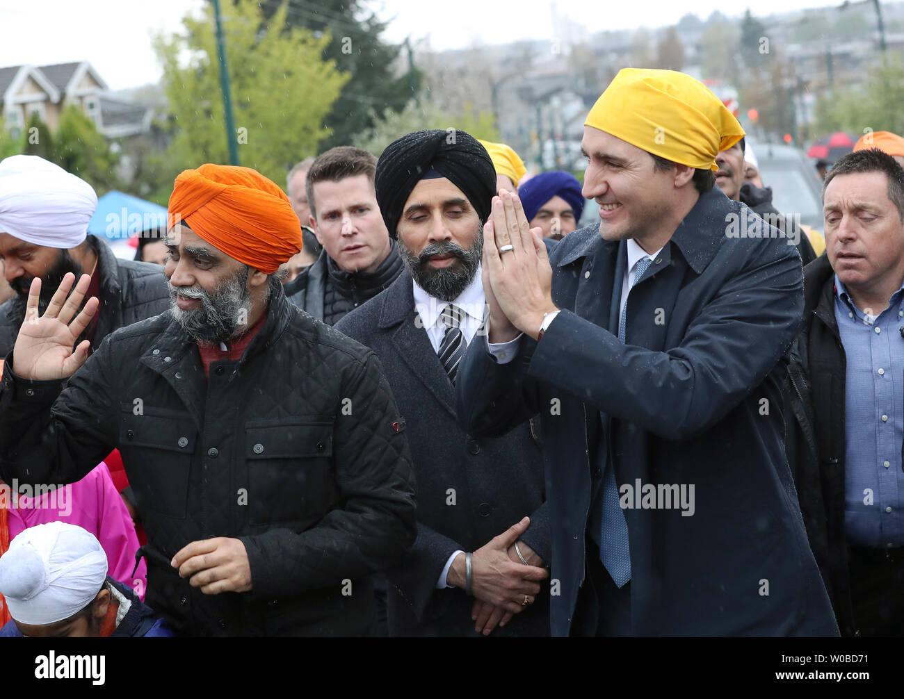 Il ministro liberale di Difesa Nazionale Harjit Sajjan (L.) e il Primo Ministro Justin Trudeau rispondere agli spettatori come cammina per la parata Vaisakhi in umido, ventoso dopo aver parlato a Khalsa Diwan della società Ross Street Temple durante Vaisakhi celebrazioni in Vancouver, British Columbia, il 13 aprile 2019, dopo che il loro governo ha di recente eliminato un riferimento di estremismo Sikh da un terrorismo 2018 relazione. Decine di migliaia di persone partecipano a questo annuale Punjabi harvest festival che commemora la fondazione della Khalsa nel 1699 dal Guru Gobind Singh e è uno dei più grandi in Nord Ameri Foto Stock