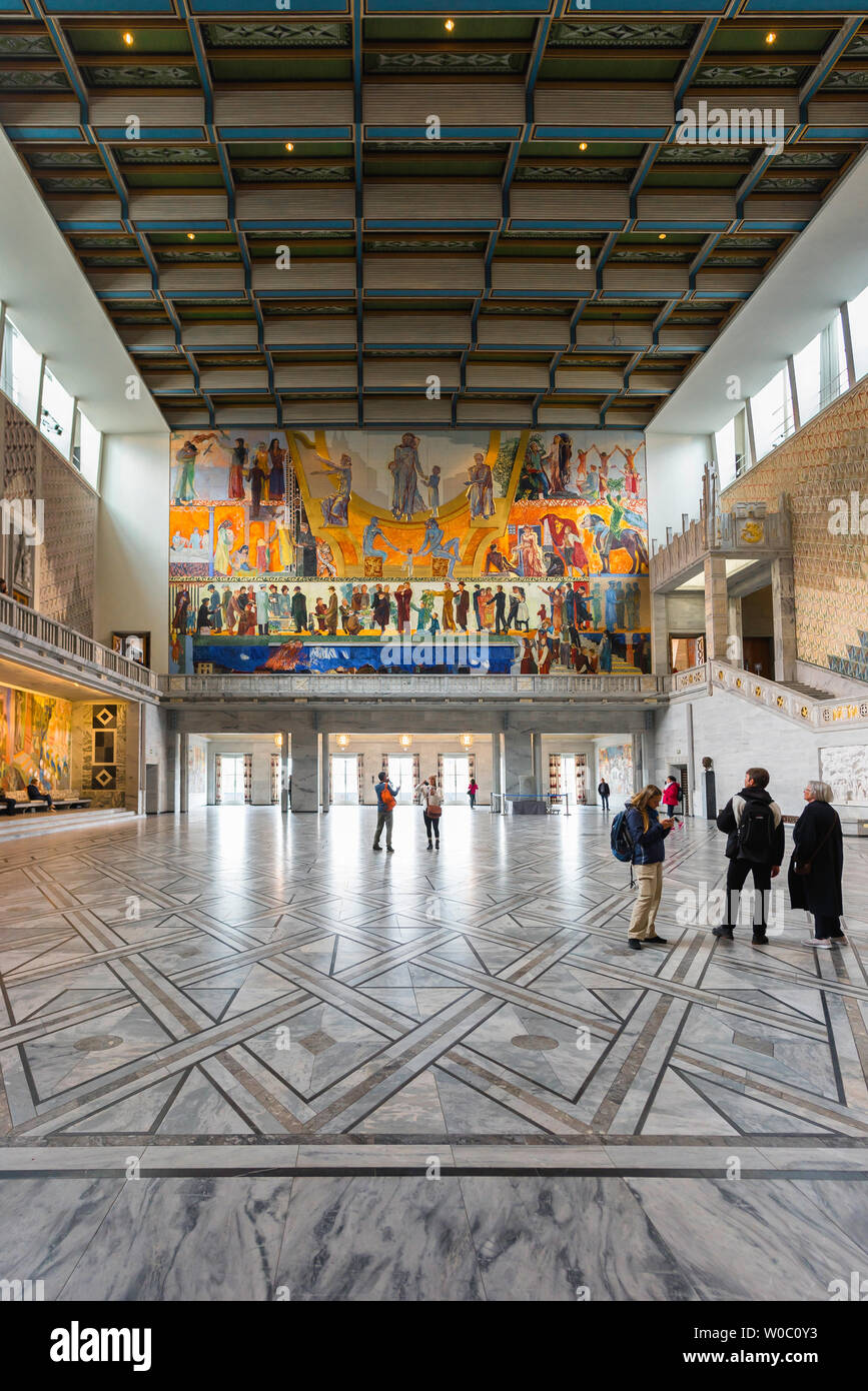 Il Municipio di Oslo, vista di turisti guardando l'enorme Henrik Sorensen pittura all'interno della grande sala in Oslo City Hall (Radhus), Norvegia. Foto Stock