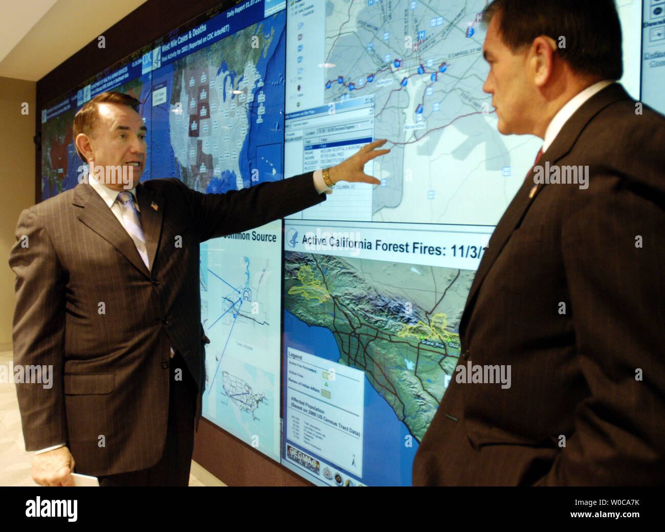 Il segretario della Sanità e dei Servizi Umani Tommy Thompson Segretario di Homeland Security Tom Ridge una televisione sistema di mappa che può visualizzare mappe in tutto il paese durante una conferenza stampa a gennaio 29, 2004 a Washington. Ridge e Thompson ha annunciato un nuovo programma per la condivisione di informazioni tra il Dipartimento della sanità e dei servizi umani e Homeland Security a contribuire alla lotta contro le armi biologiche e di sostenere la lotta delle malattie contagiose. (UPI foto/Michael Kleinfeld) Foto Stock