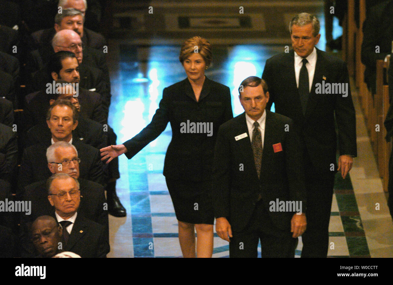 Laura Bush rubinetti del Primo Ministro britannico Tony Blair sulla spalla come lei e il Presidente George W Bush a piedi ai loro posti prima del funerale di stato dell'ex Presidente Ronald Reagan alla Cattedrale Nazionale di Washington, 11 giugno 2004. I leader del mondo ha reso omaggio al quarantesimo presidente degli Stati Uniti. (UPI foto/Pat Benic) Foto Stock