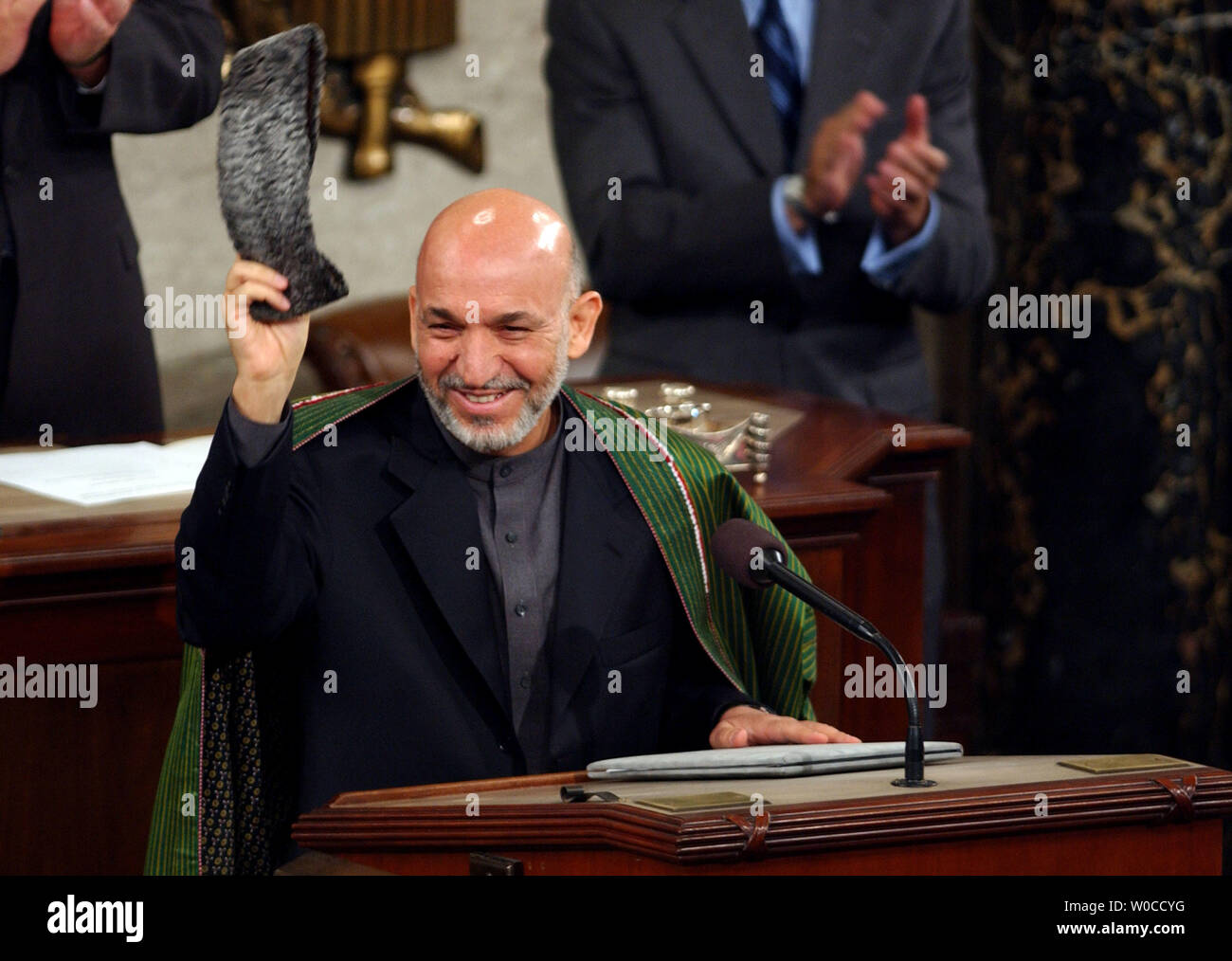 Il presidente dell'Afghanistan, Hamid Karzai onde da applausi prima di affrontare una riunione congiunta del Congresso il 15 giugno 2004 presso il Campidoglio di Washington. Karzai ha detto che la guerra contro il terrore nel suo paese è ancora in corso e ha chiesto per un continuo supporto americano. L'Afghanistan ha le prime elezioni nelle settimane seguenti. (UPI foto/Michael Kleinfeld) Foto Stock