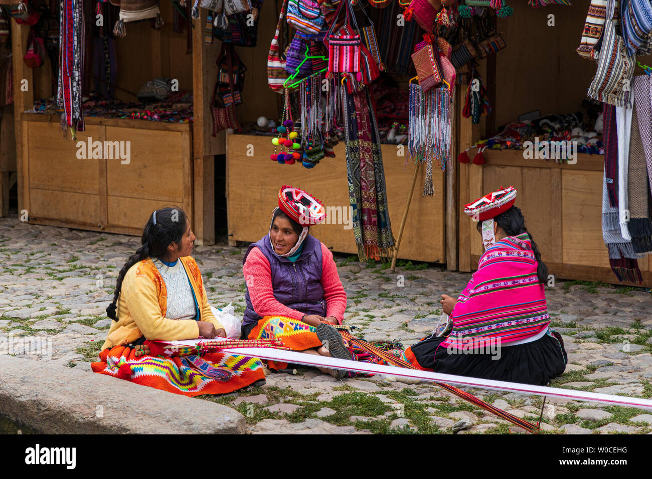 Signore locale in chat e la tessitura nel mercato di Ollantaytambo, Valle Sacra, Perù, Sud America Foto Stock