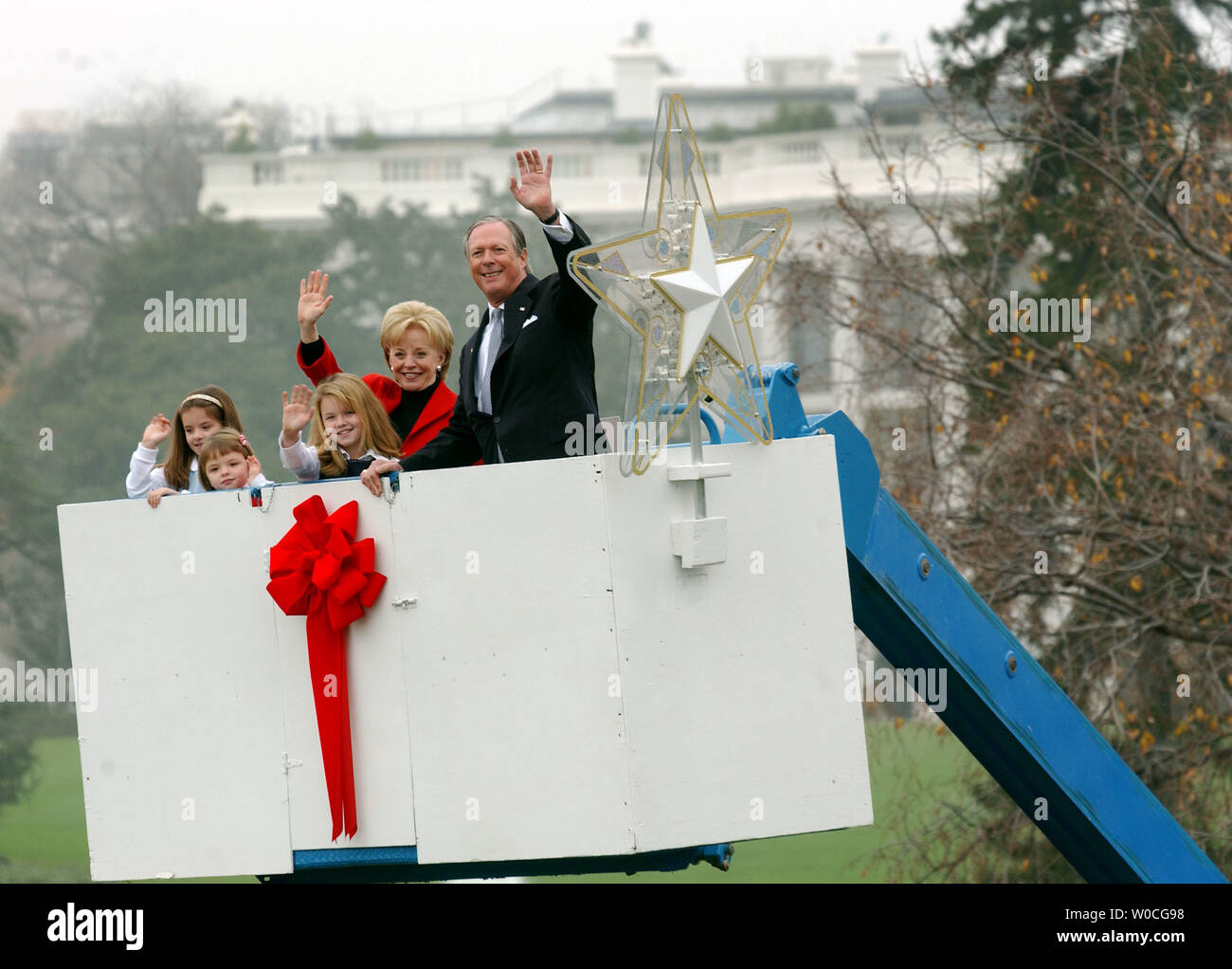 Peter Nostrand, Presidente del corteo di Natale di pace, insieme con Lynne Cheney e nipoti, Grazia Perry, Elizabeth Perry e Kate Perry onda per la folla dopo la messa la stella in cima alla nazionale di albero di Natale di fronte al South Lawn della Casa Bianca nel novembre 23, 2004 a Washington. L'illuminazione ufficiale della struttura sarà il 2 dicembre 2004. (UPI foto/Michael Kleinfeld) Foto Stock