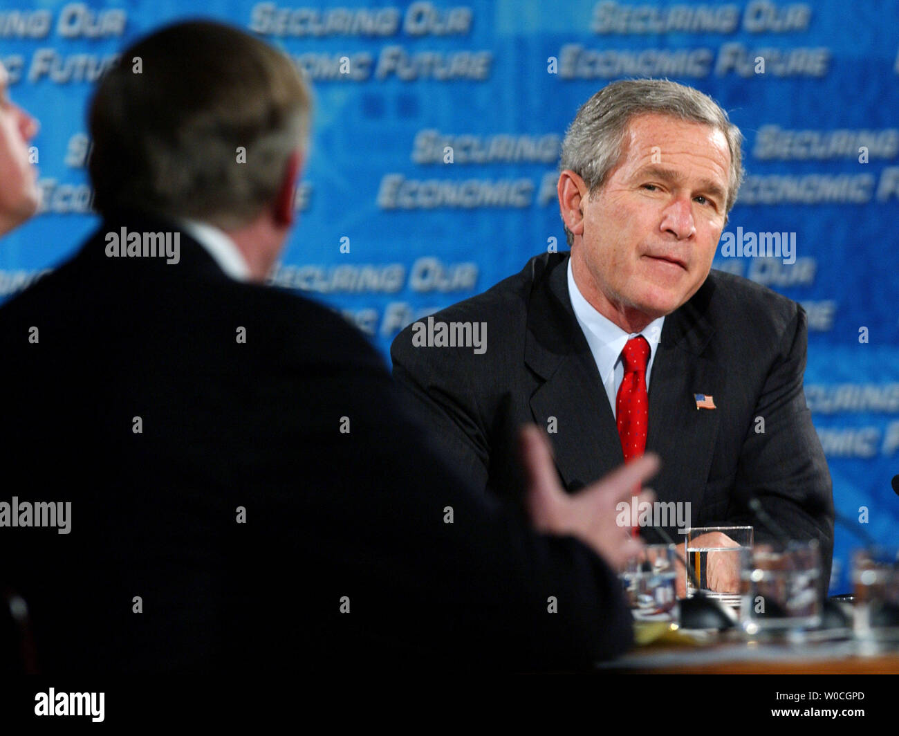 Il Presidente George W Bush ascolta come George Sacerdote di Yale Law School parla di una casa bianca sponsorizzato conferenza sull'economia a Reagan Trade Center il 15 dicembre 2004 a Washington. Lo scopo della conferenza è quello di stabilire il consenso economica e politica per i prossimi quattro anni dell'amministrazione Bush. (UPI foto/Michael Kleinfeld) Foto Stock