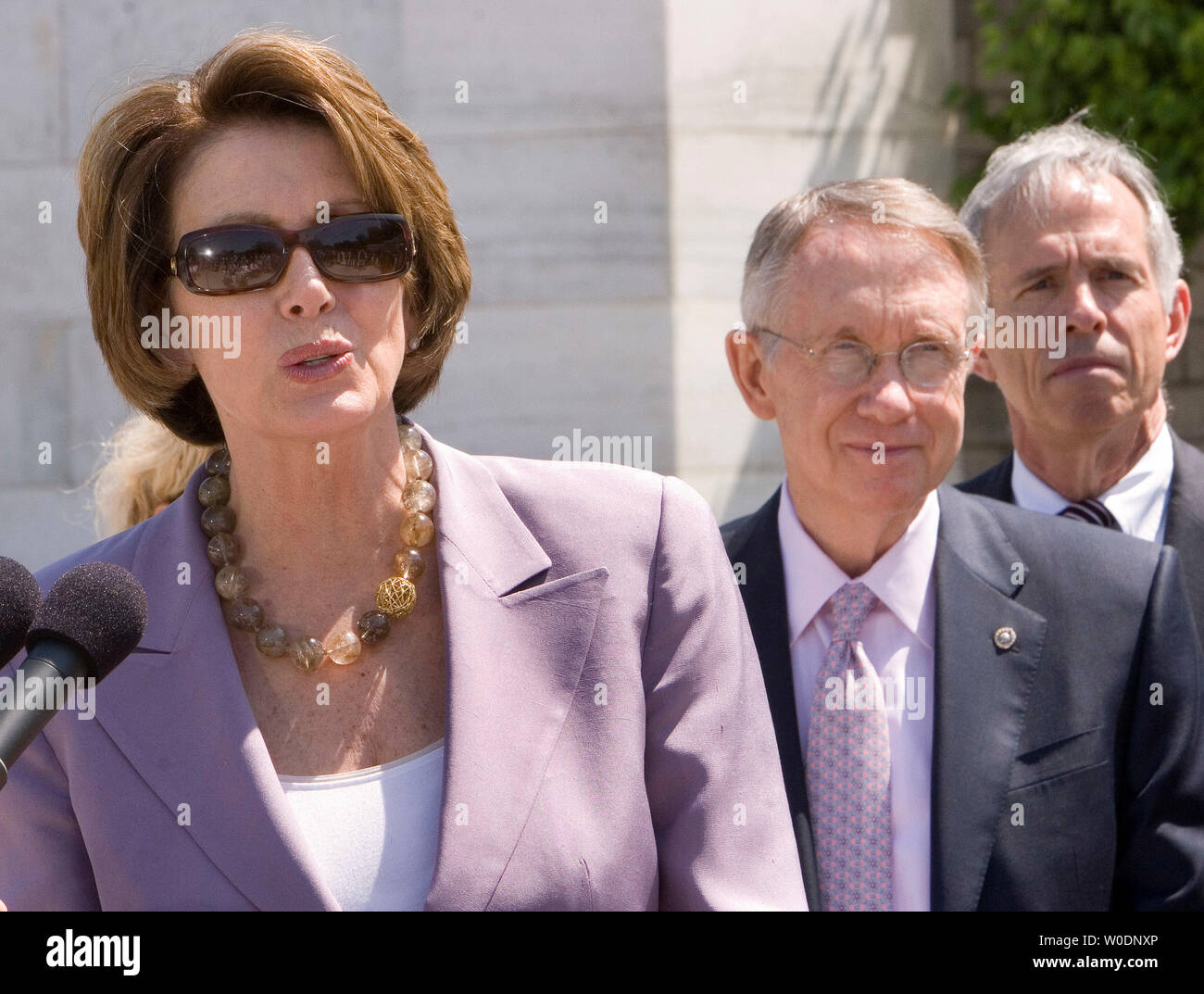 Il leader della maggioranza del senatore Harry Reid (D-NV) (C) ascolta come il Presidente della Camera Nancy Pelosi (D-CA) (L) parla di iniziative per rendere il Campidoglio "più verde" e migliorare l'efficienza energetica in occasione di una conferenza stampa su scalini del Capitol a Washington il 21 giugno 2007. I Democratici ha detto che il Congresso dovrebbe prendere passi ambientale presso il Campidoglio e al fine di essere un esempio positivo per il popolo americano. (UPI foto/David Brody) Foto Stock