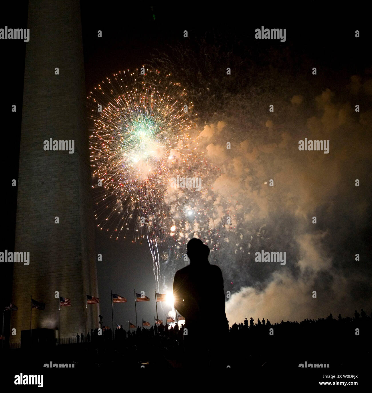 Un uomo orologi il quarto di luglio mostra fuochi d'artificio per celebrare il Giorno di Indipendenza sul Mall di Washington il 4 luglio 2007. (UPI foto/David Brody) Foto Stock