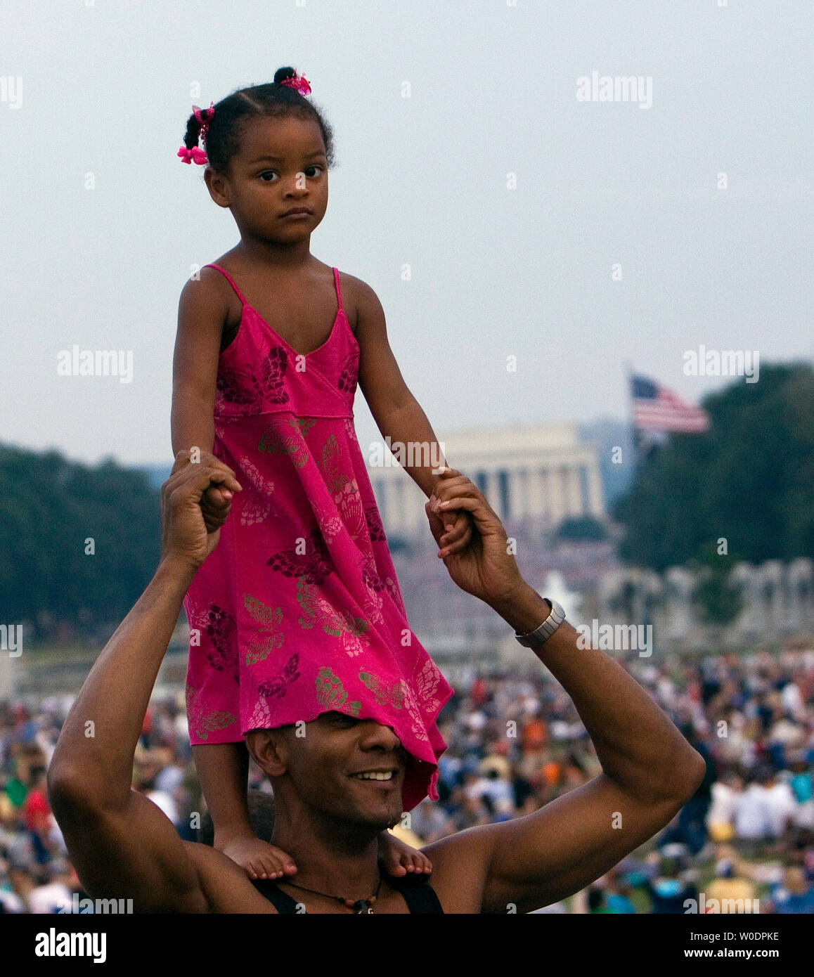 Taylor diNovo-Bell, 2, si erge sulle spalle di suo padre Tom Bell, sul Mall di Washington mentre si celebra il Giorno di Indipendenza e in attesa di vedere lo spettacolo di fuochi artificiali su 4 Luglio, 2007. (UPI foto/David Brody) Foto Stock