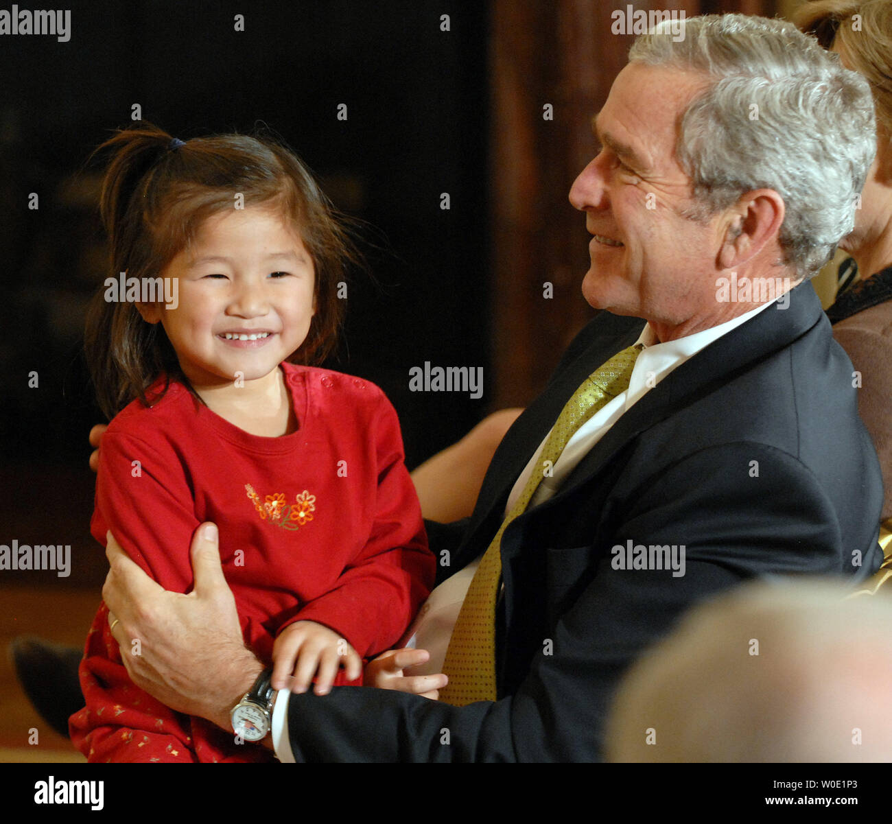 Stati Uniti Il Presidente George W Bush di paranchi di sollevamento di una giovane ragazza sul suo giro durante l'intrattenimento in onore di Adozione nazionale al giorno nella Sala Est della Casa Bianca del 16 novembre 2007. (UPI foto/Roger L. Wollenberg) Foto Stock